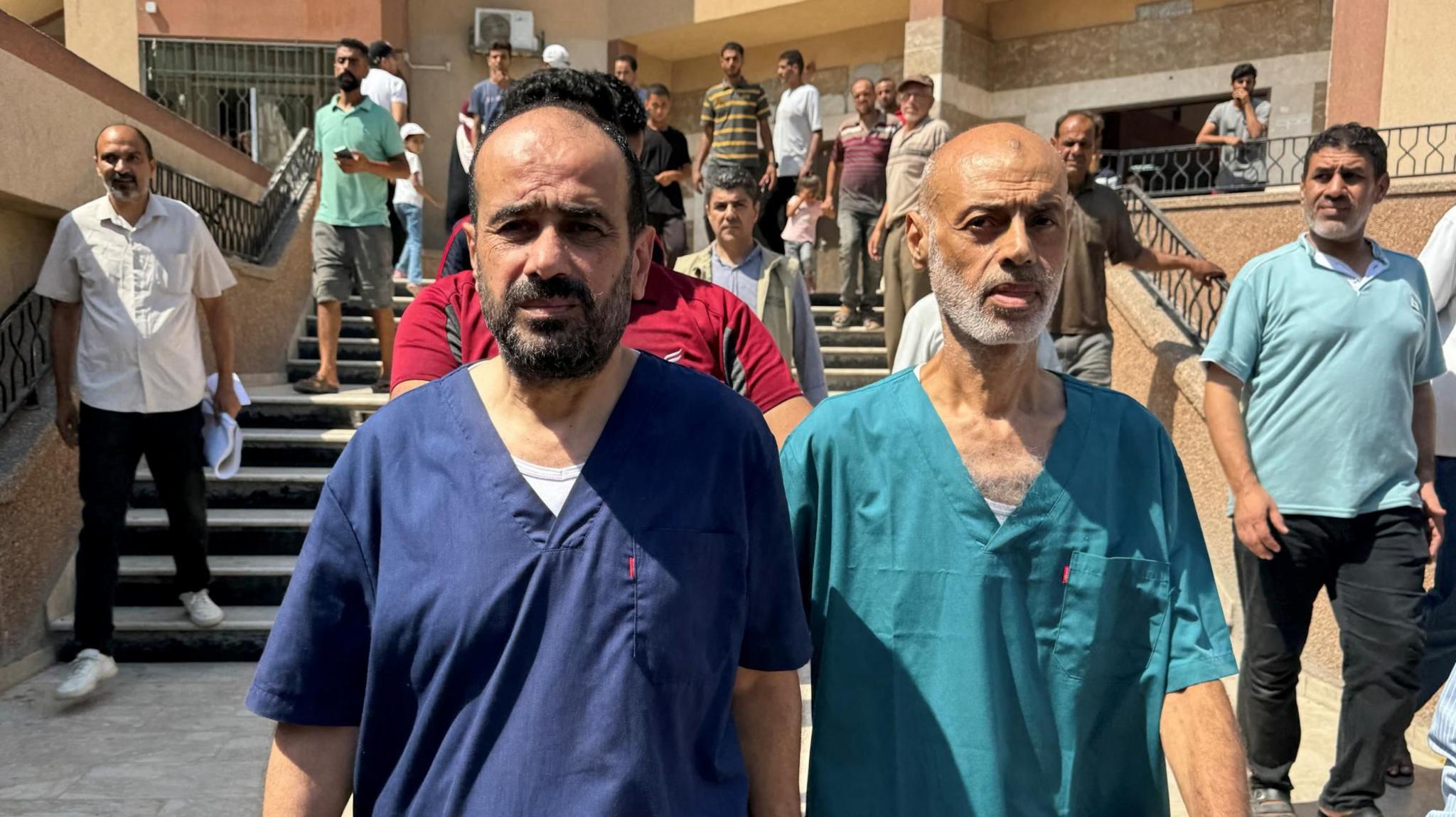 Dr Mohammed Abu Salmiya (L) and a colleague walks to a press conference at Nasser hospital in Khan Youins, in the southern Gaza Strip, following their release from Israeli detention (1 July 2024)