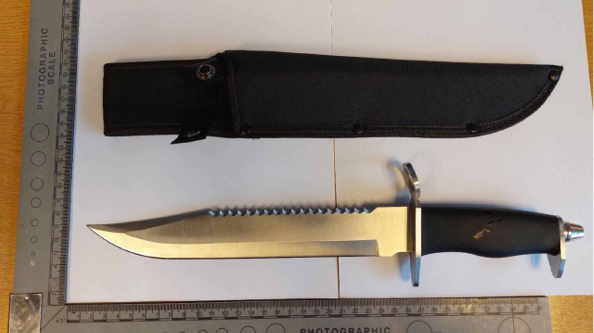 A 15in (37.5cm) hunting knife next to a black sheath