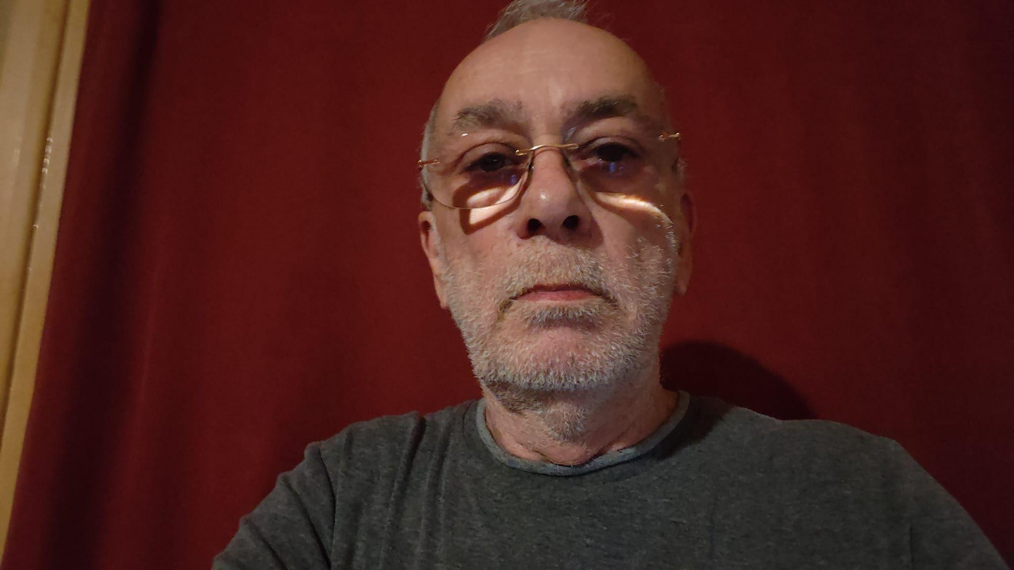A medium close up of James Williams wearing a grey top and glasses