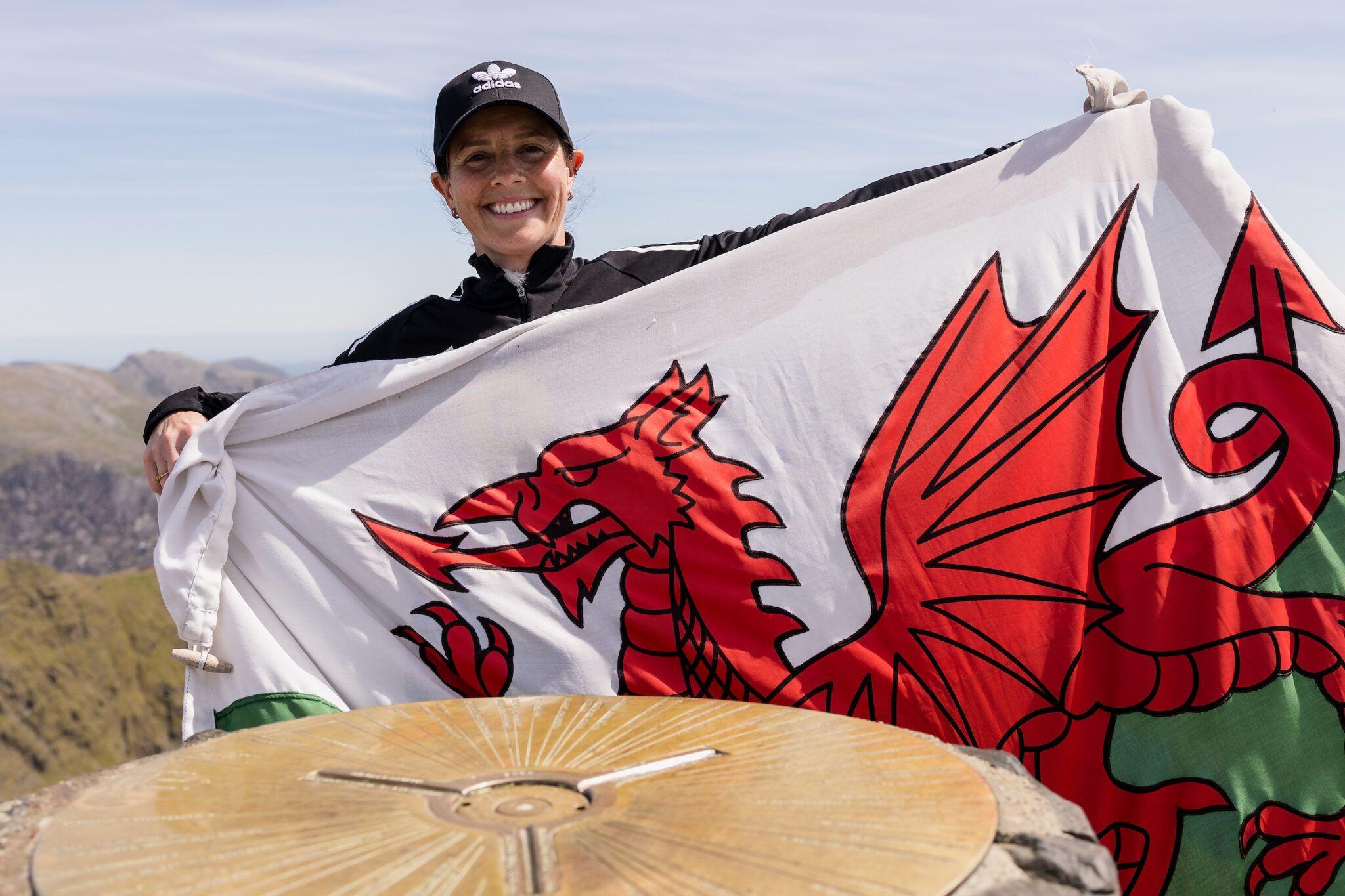 Coach Rhian Wilkinson with Wales flag on the top of Yr Wyddfa