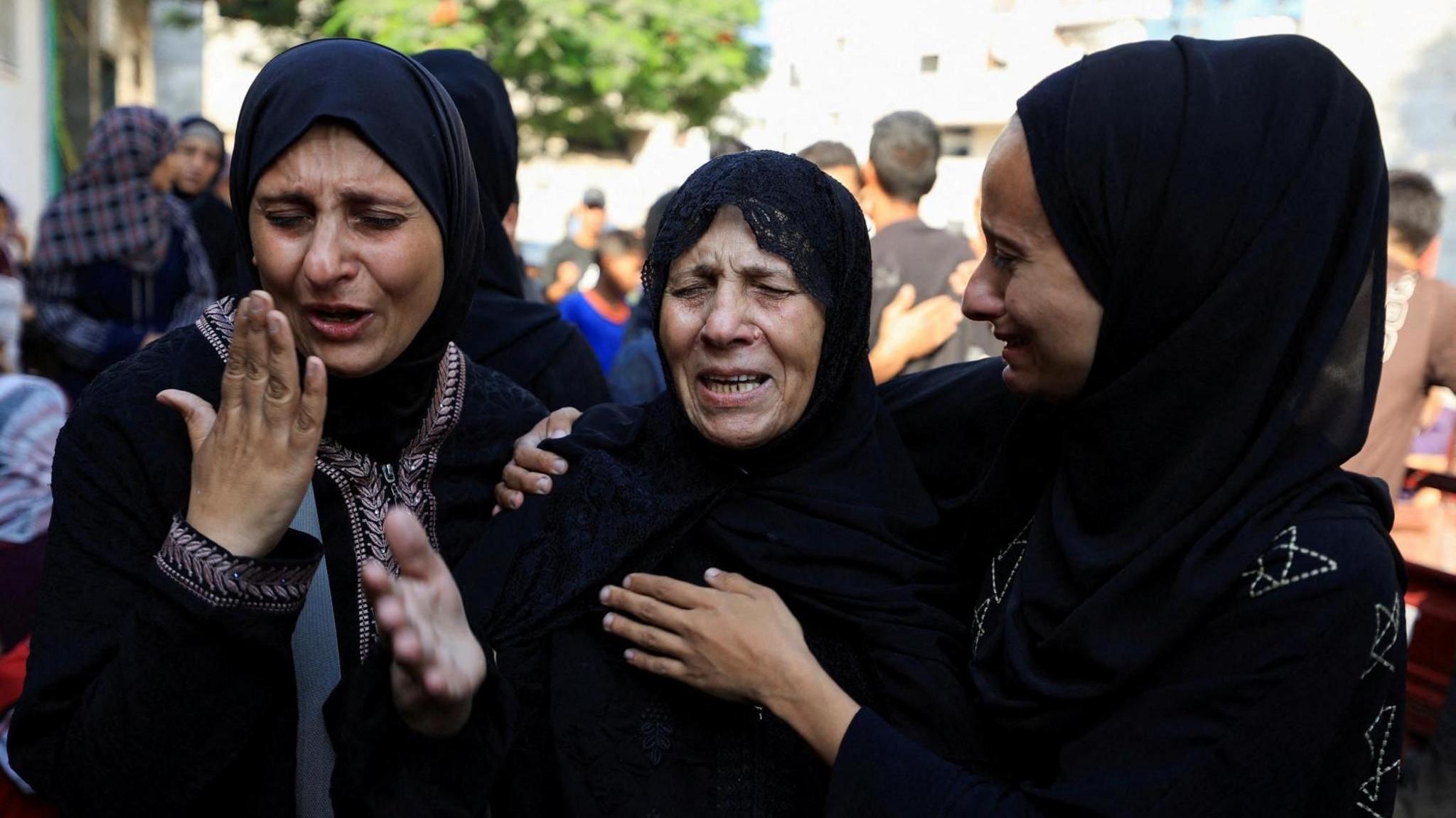 Three women cry at a funeral in Al-Shifa Hospital in Gaza.