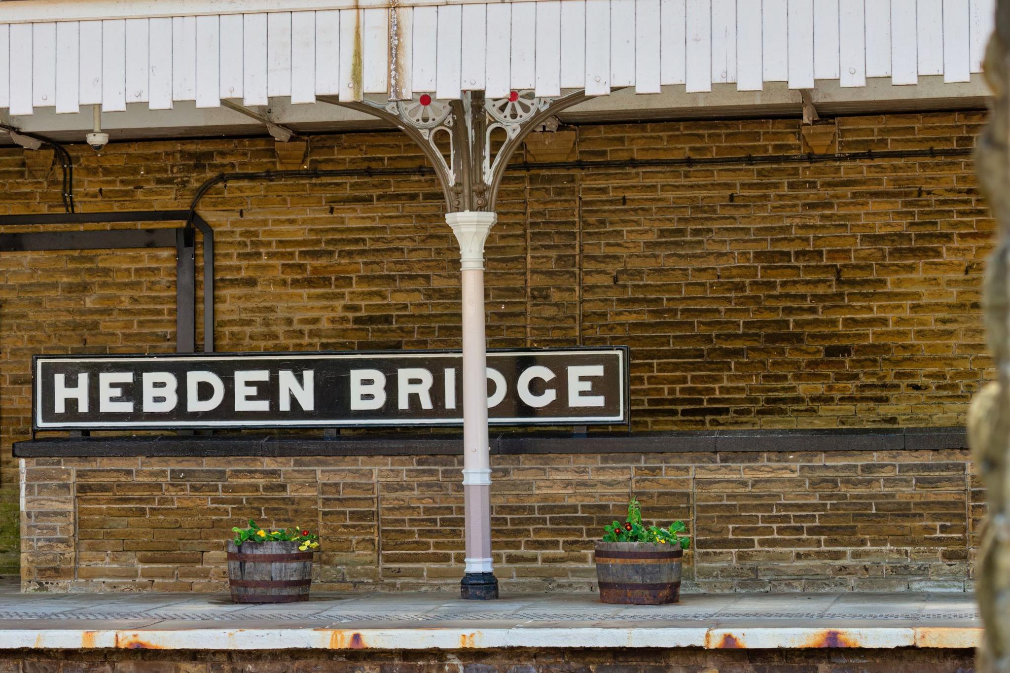 Victorian-era station with wought iron pillars and yellowing bricks turned black by soot