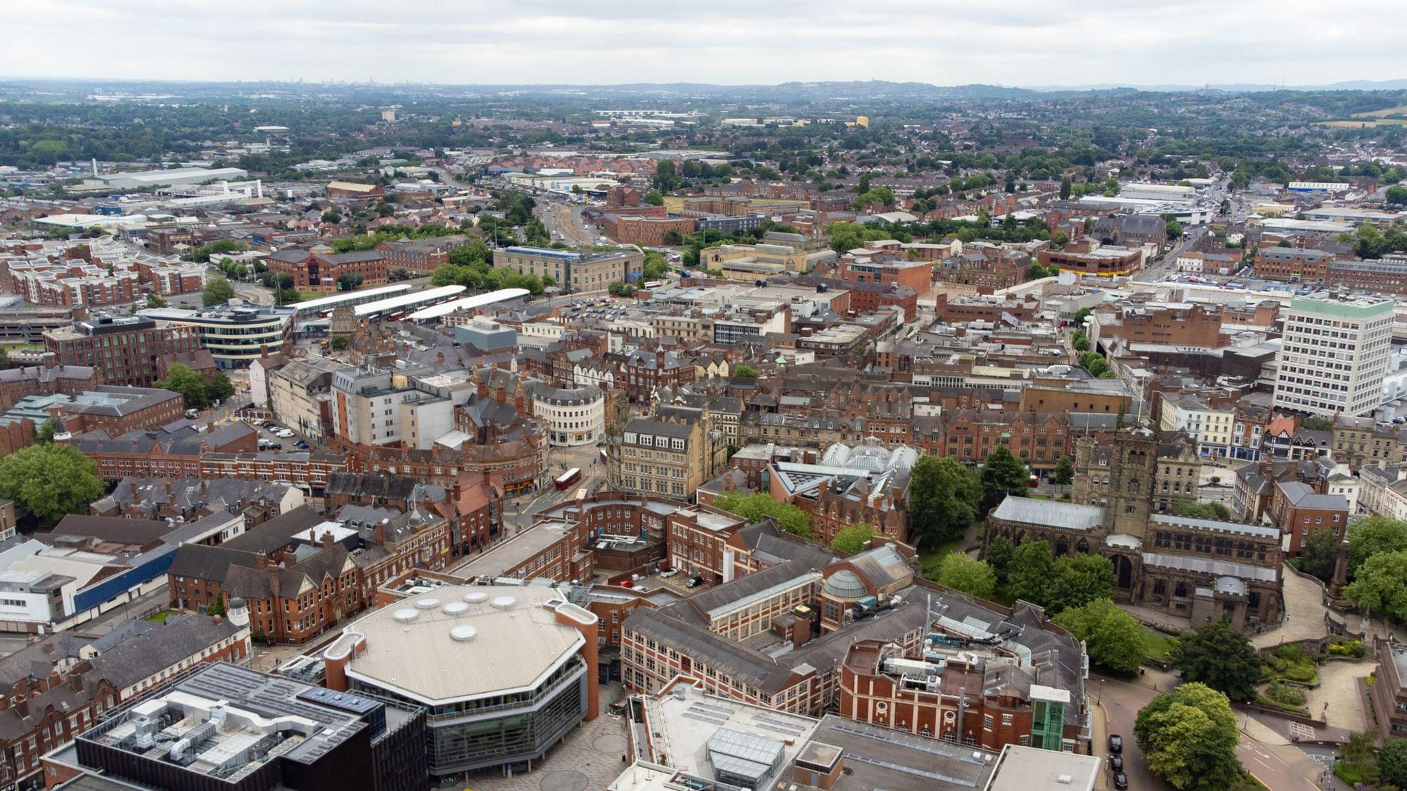 An aerial view of Wolverhampton. There are lots of buildings and the skyline goes for miles. It is a clear day. 