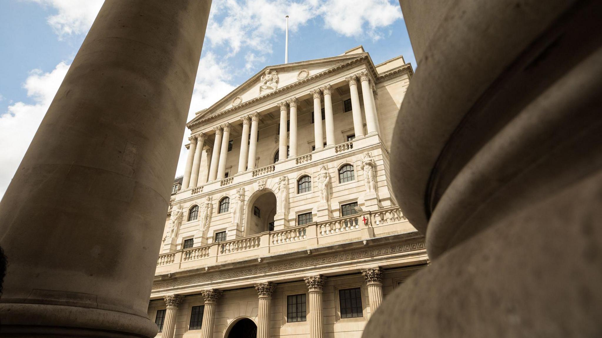 External shot of the Bank of England building taken from a low view with pillars either side in the foreground.