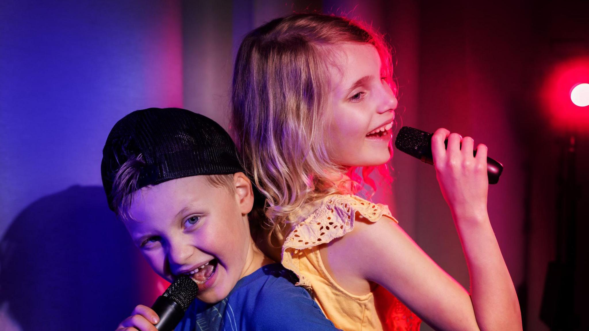 children singing into microphones
