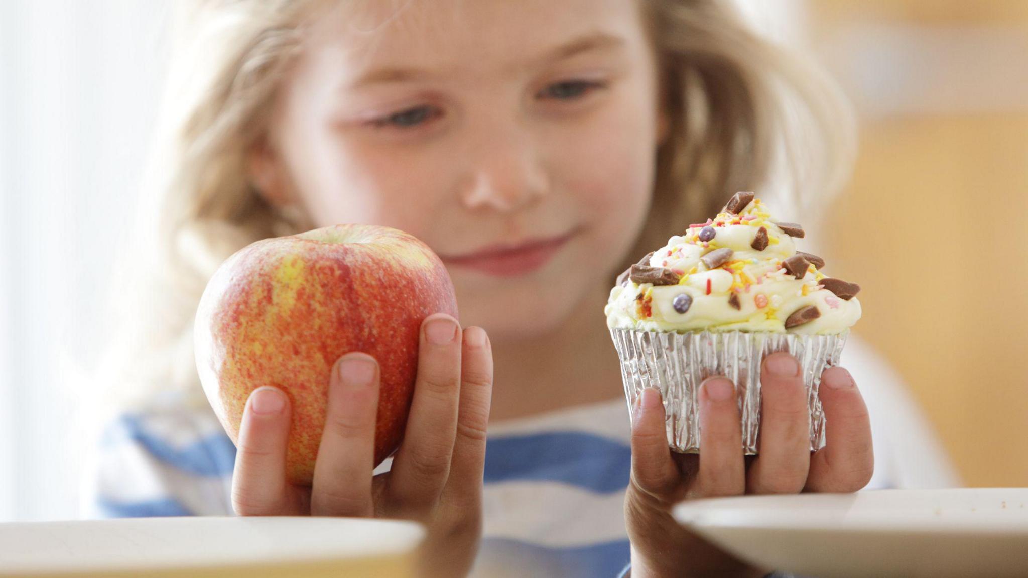 Girl holding a cake and an apple