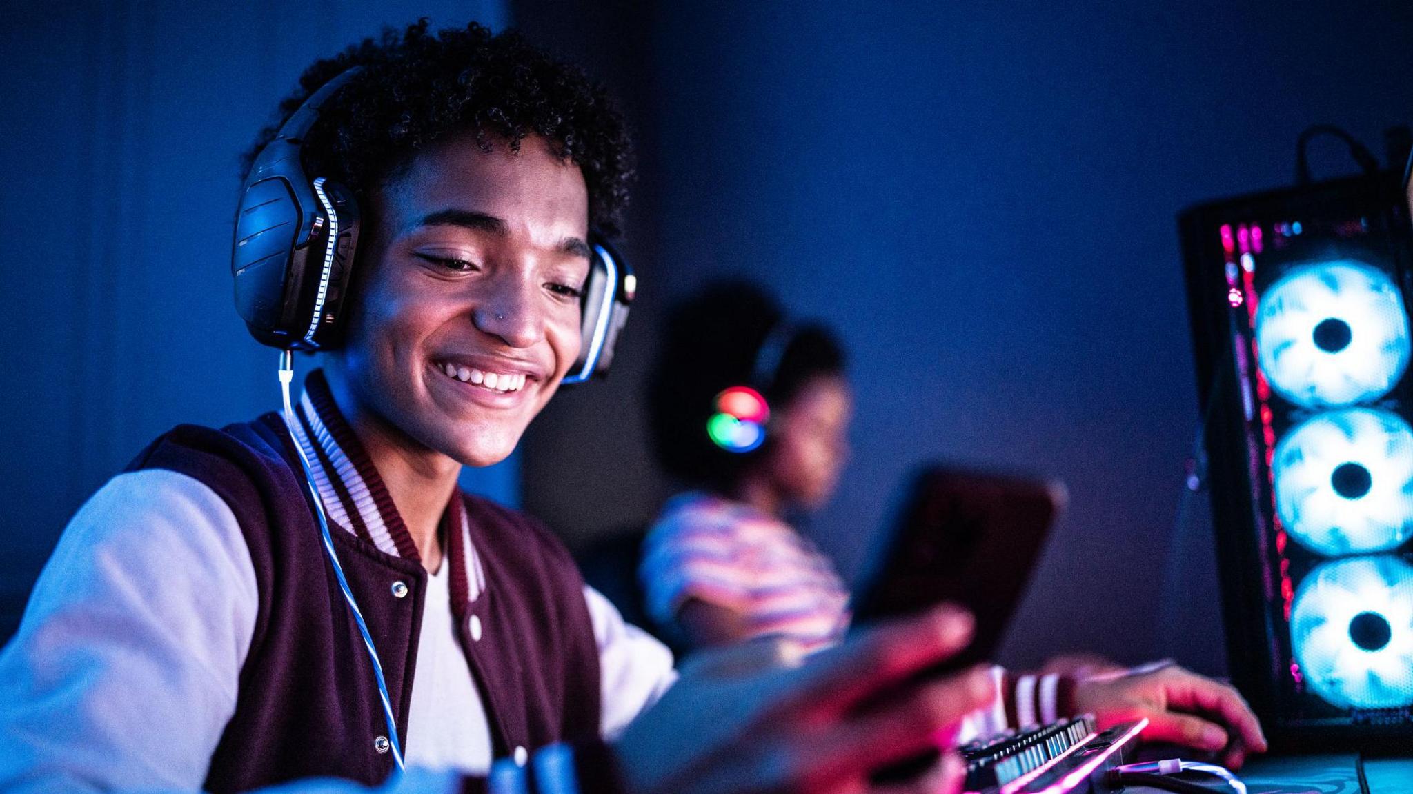 a boy looking at his mobile phones while gaming