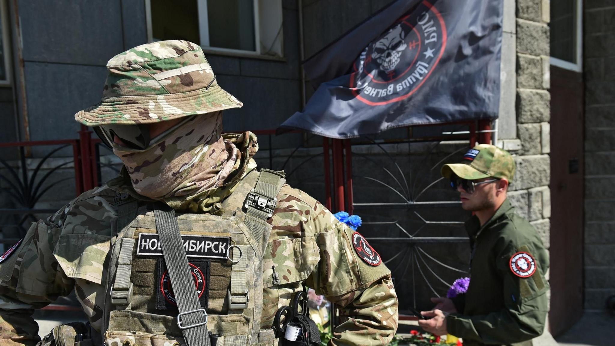 Fighters of Wagner private mercenary group visit at a makeshift memorial with portraits of Russian mercenary chief Yevgeny Prigozhin