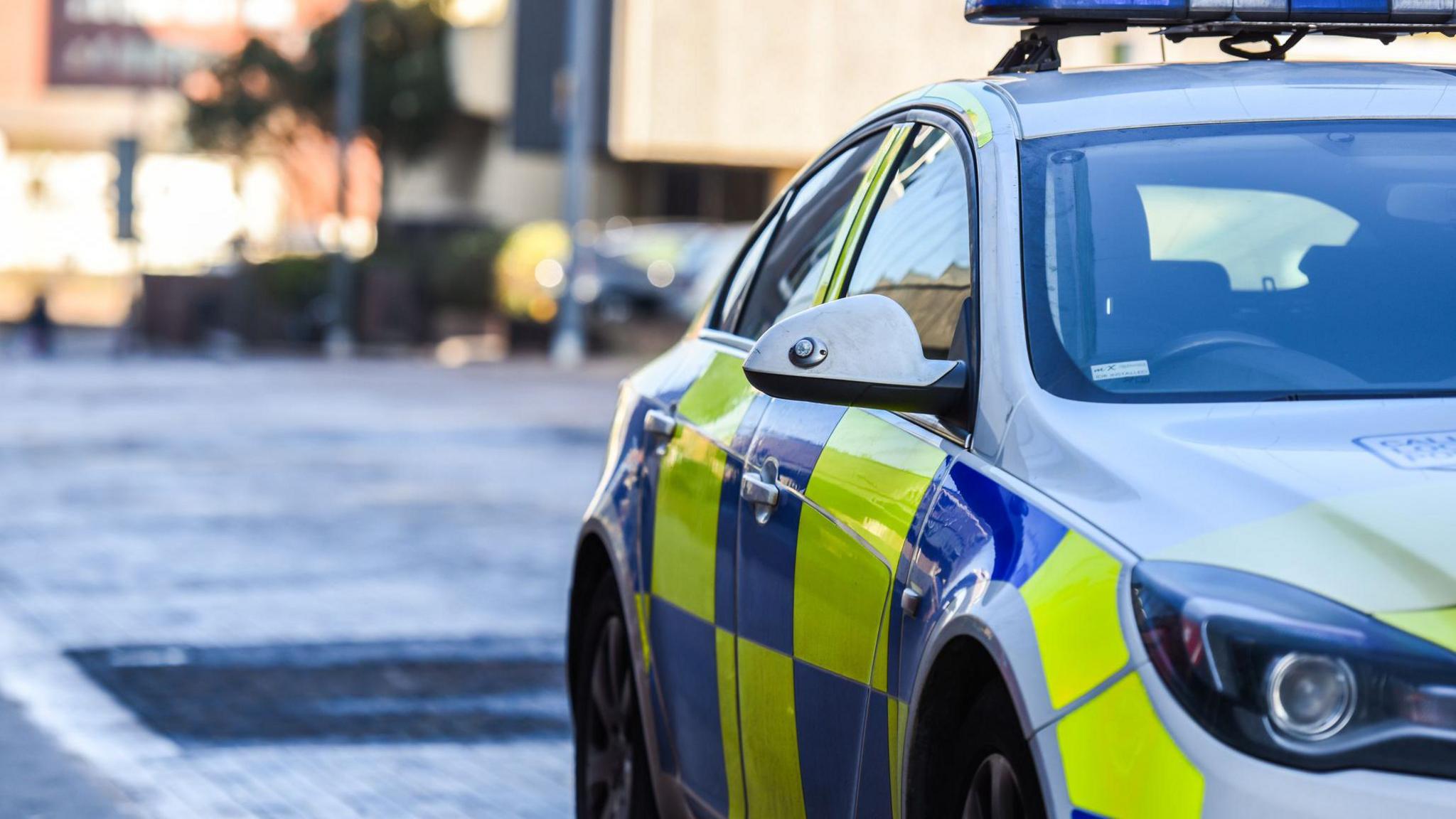 A picture of the side of a parked patrol police car, with no force insignia. 