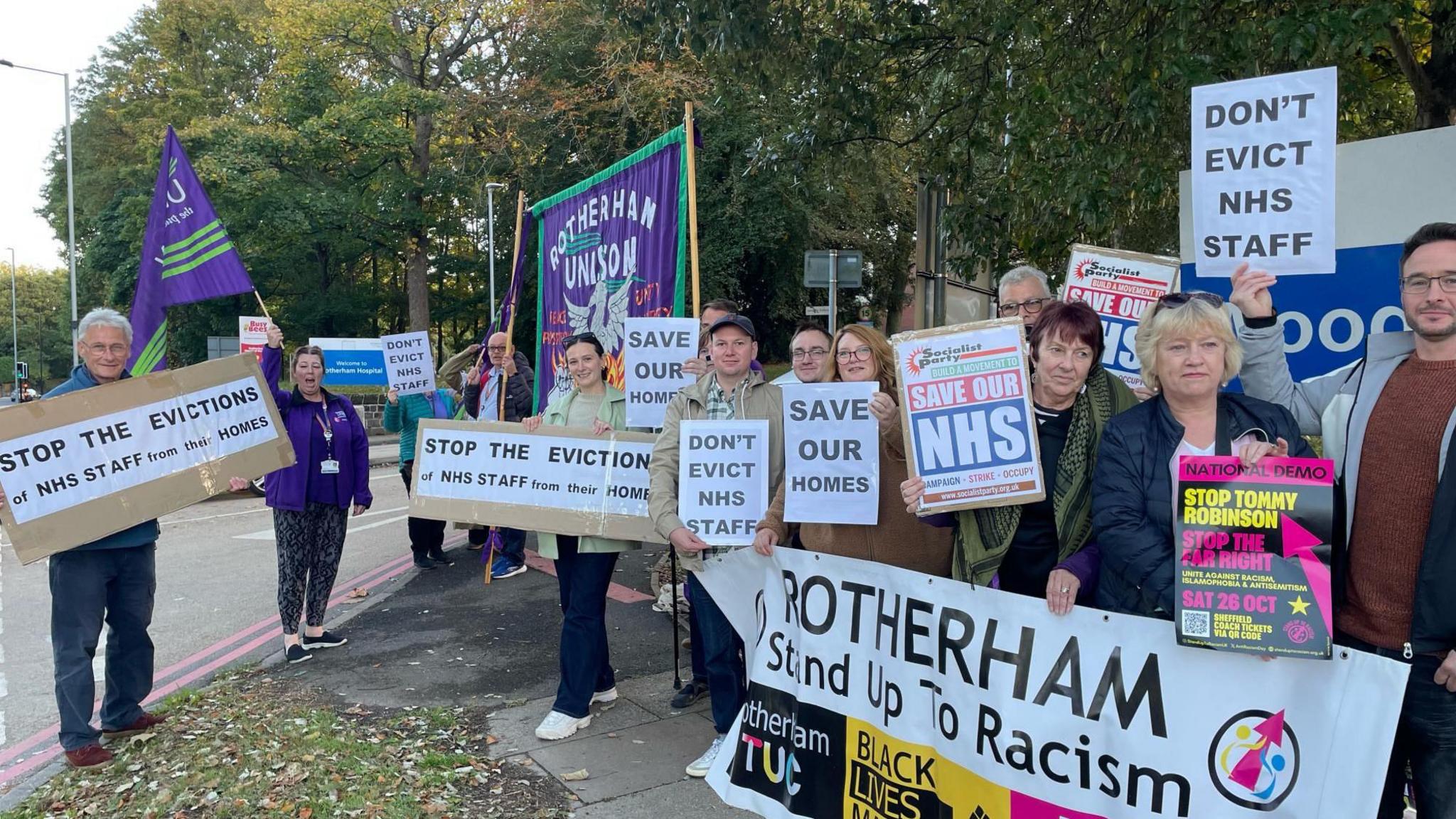 A large group of people looking angry holding banners