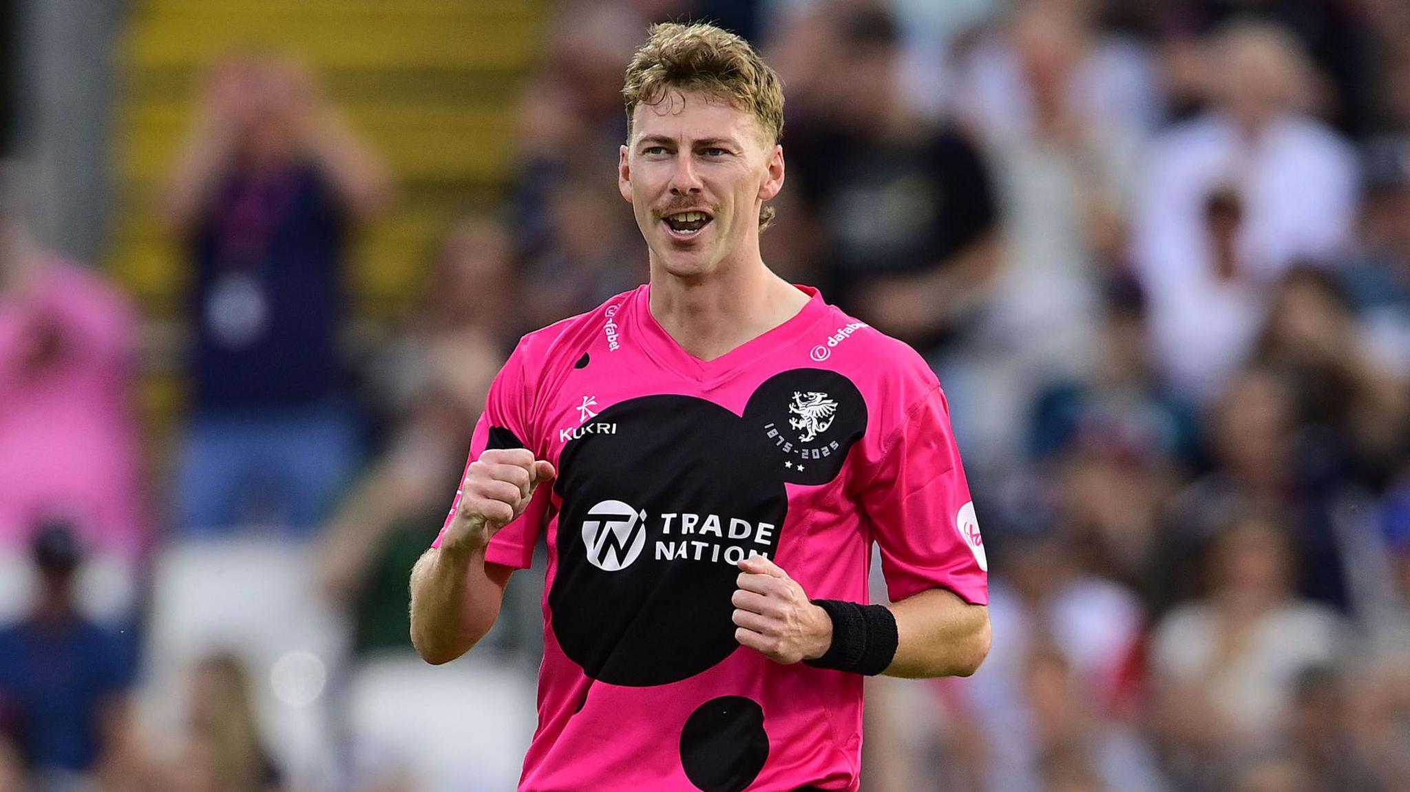 Riley Meredith clenches his fists in celebration while on the pitch during a Somerset match