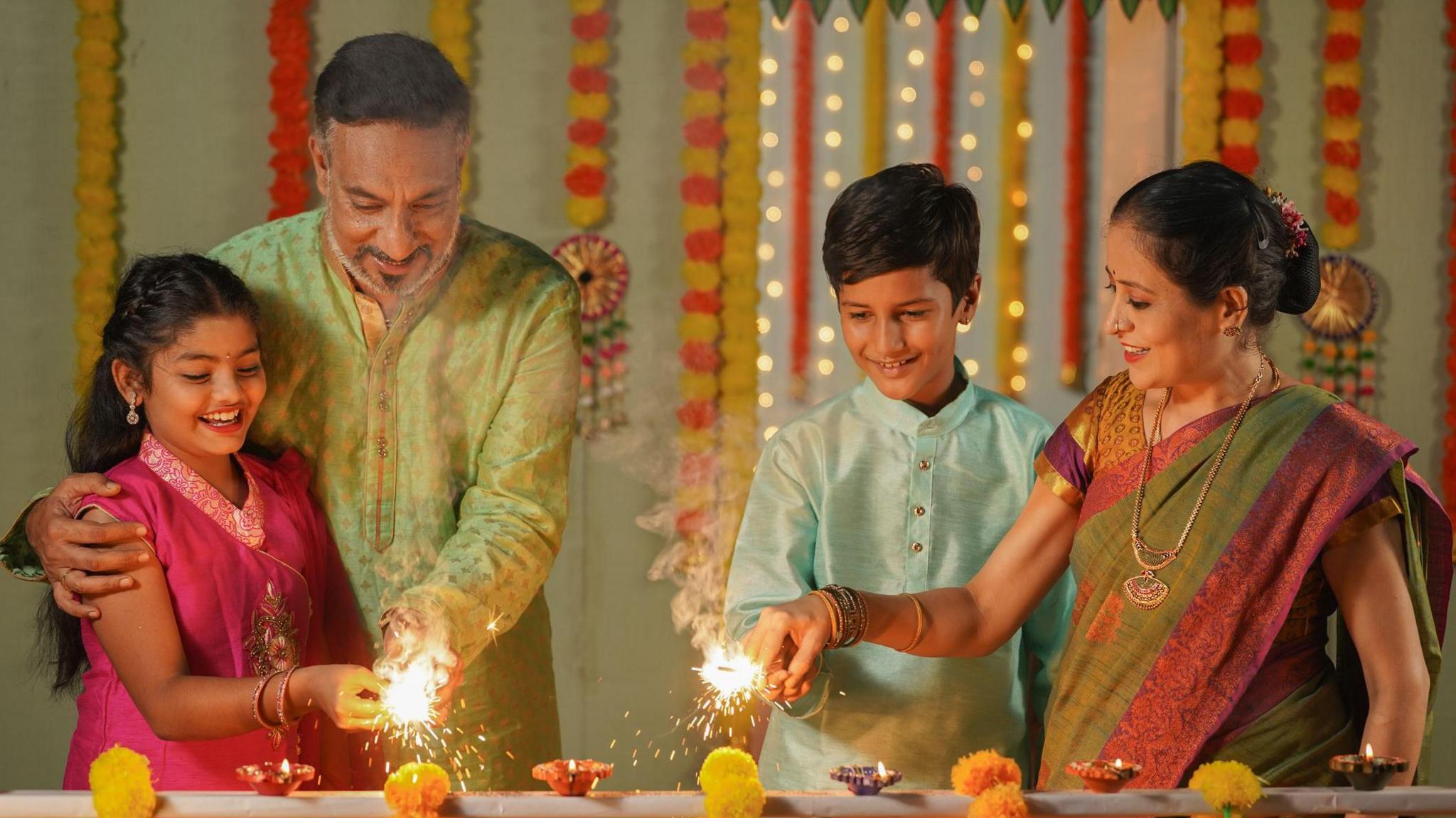A family celebrating Diwali with sparklers.