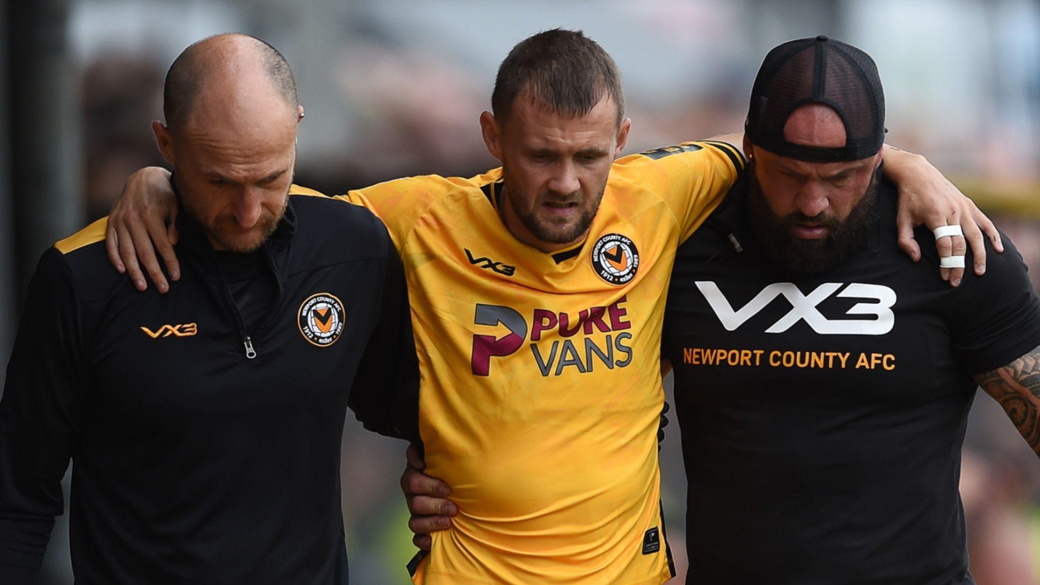 Newport's Shane McLoughlin is helped off the pitch after injury