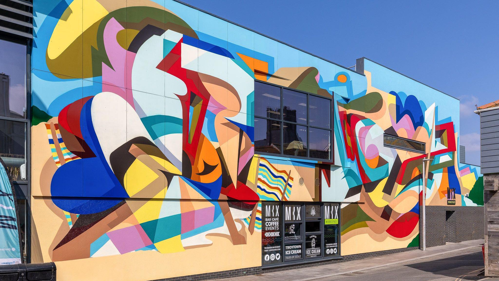 A giant colourful mural painted on the front of the building