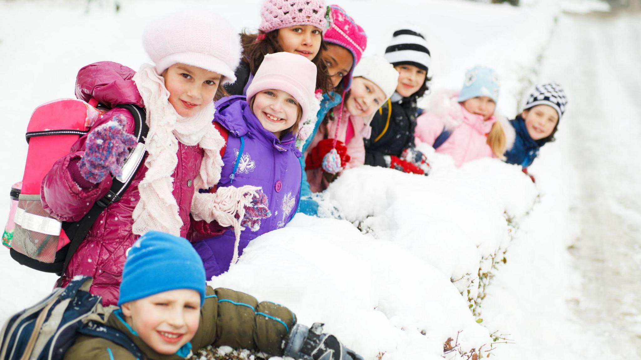 children outside in the snow smiling