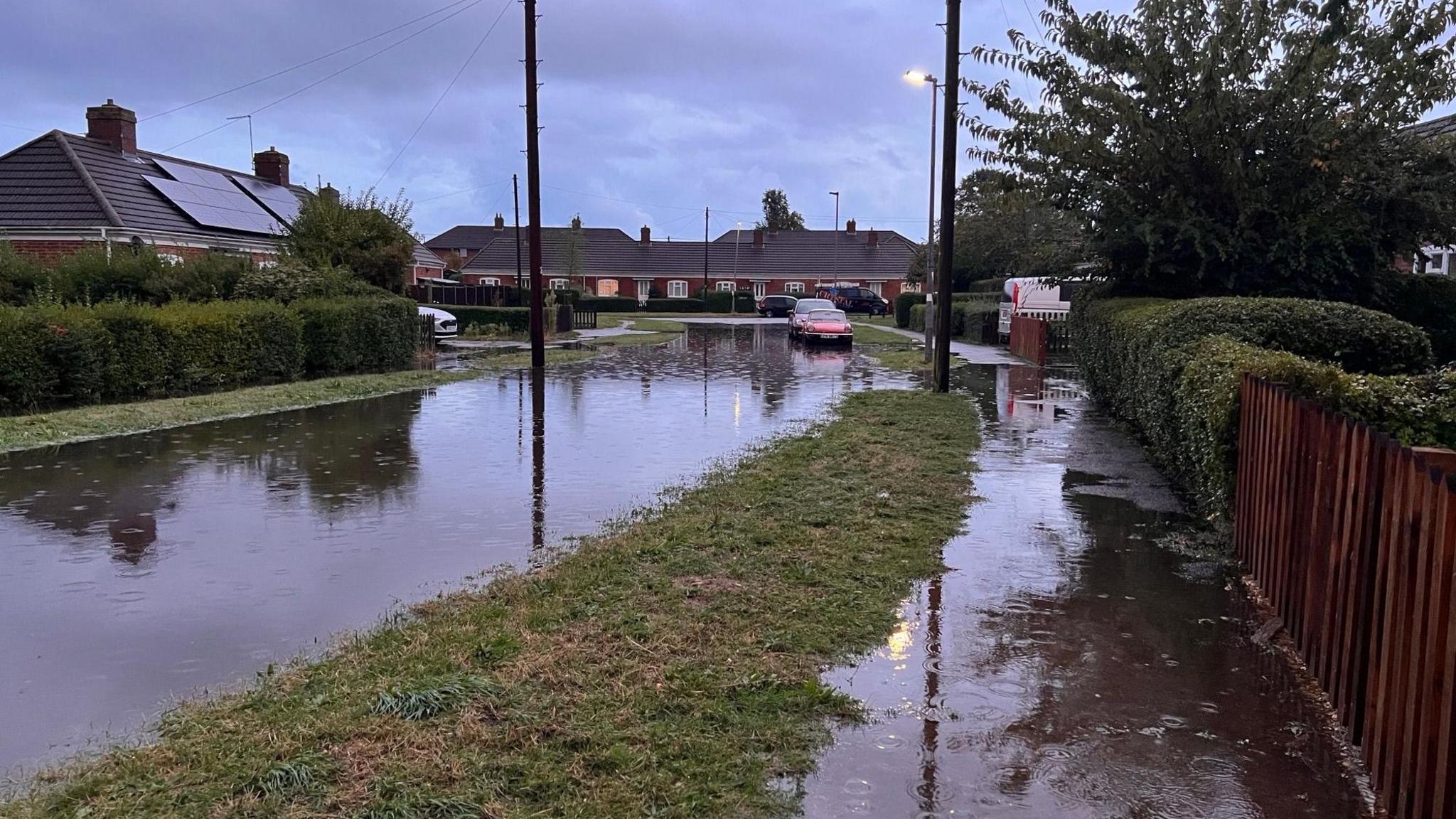 A street with flooding on the road and pavement 