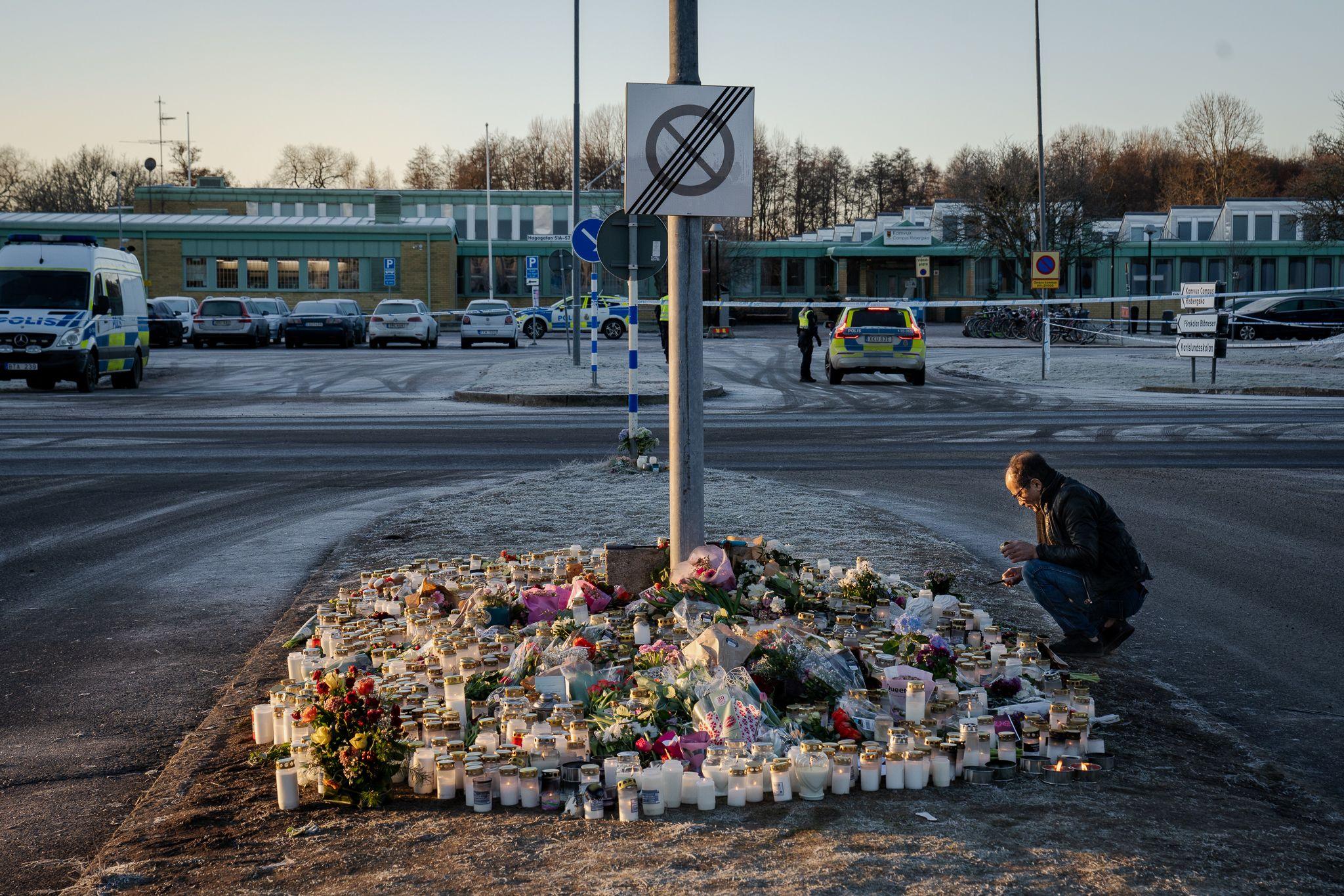 A man lights a candle at a memorial opposite the Risbergska school in Orebro. Ten people were killed in the attack, as well as the gunman.