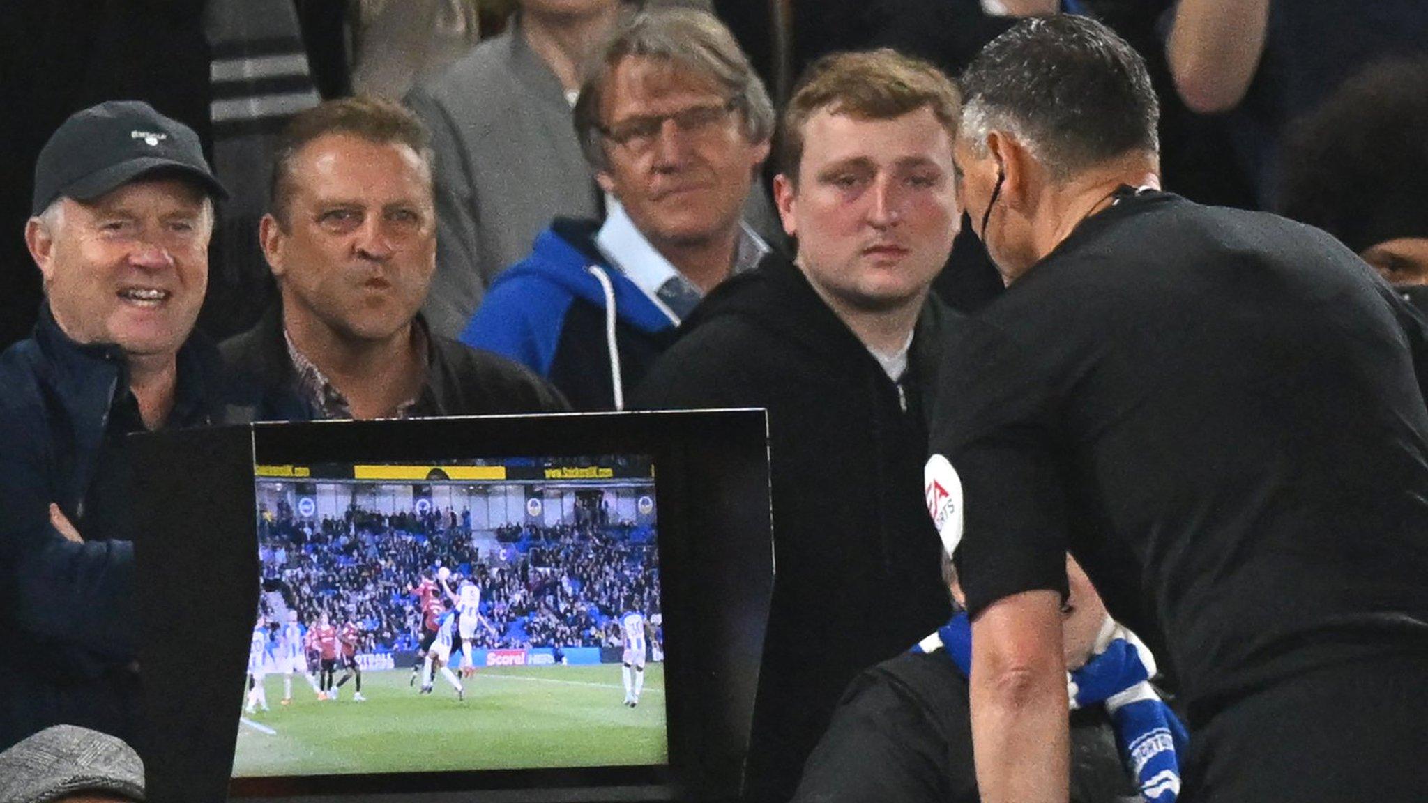 Referee Andre Marriner checks the pitchside VAR monitor before awarding Brighton a penalty against Manchester United