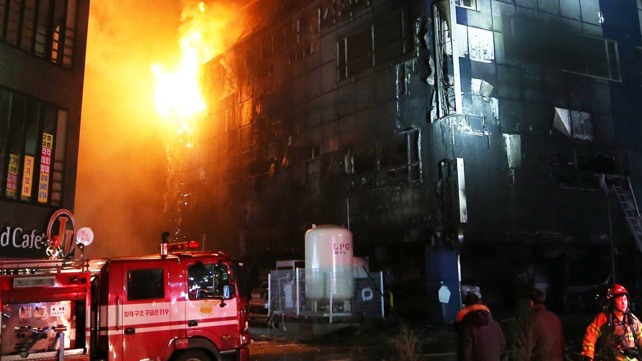 A fire engine and firefighters at the scene of the blaze at night time