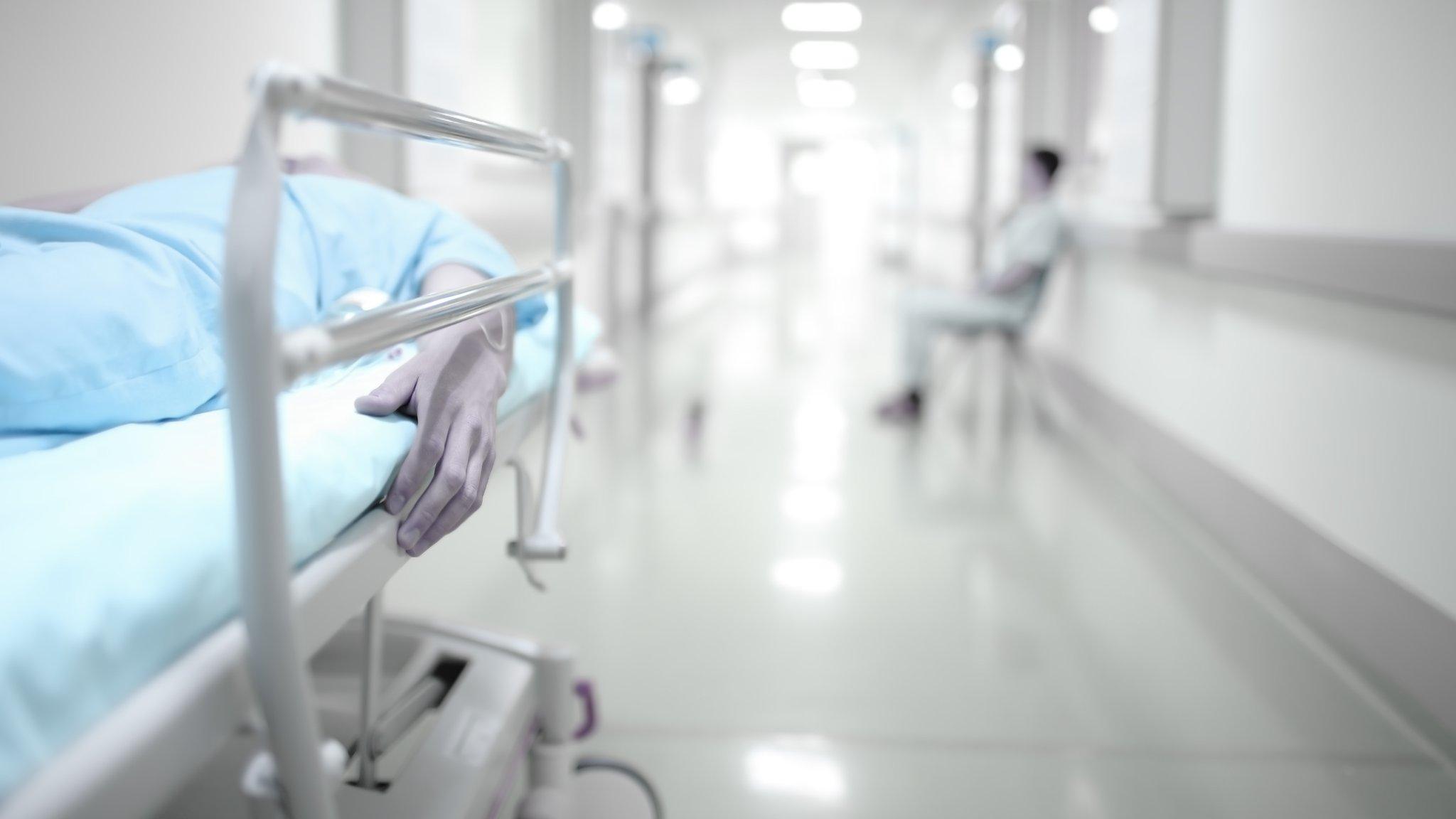 Person lying in hospital corridor