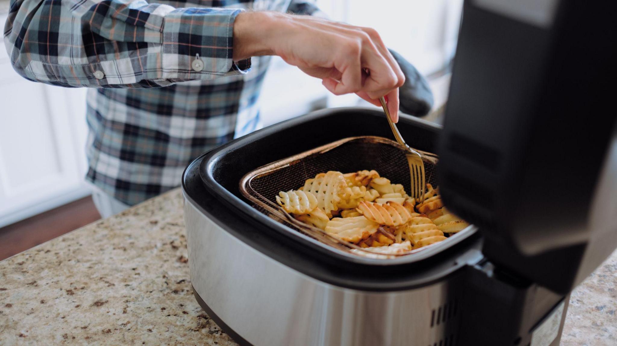 Man uses an air fryer