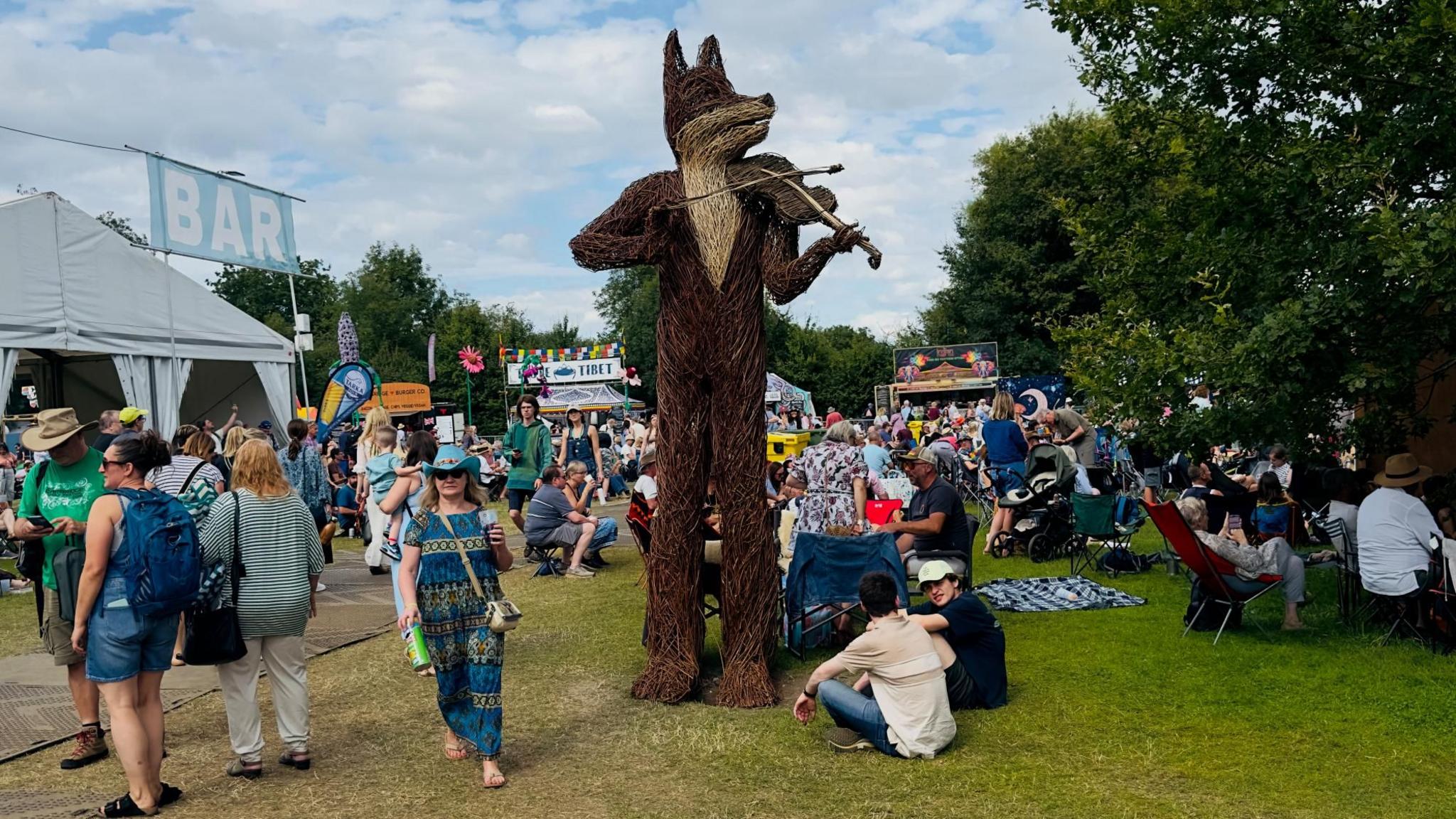 A willow sculpture of a fox playing a fiddle at the Cambridge Folk Festival