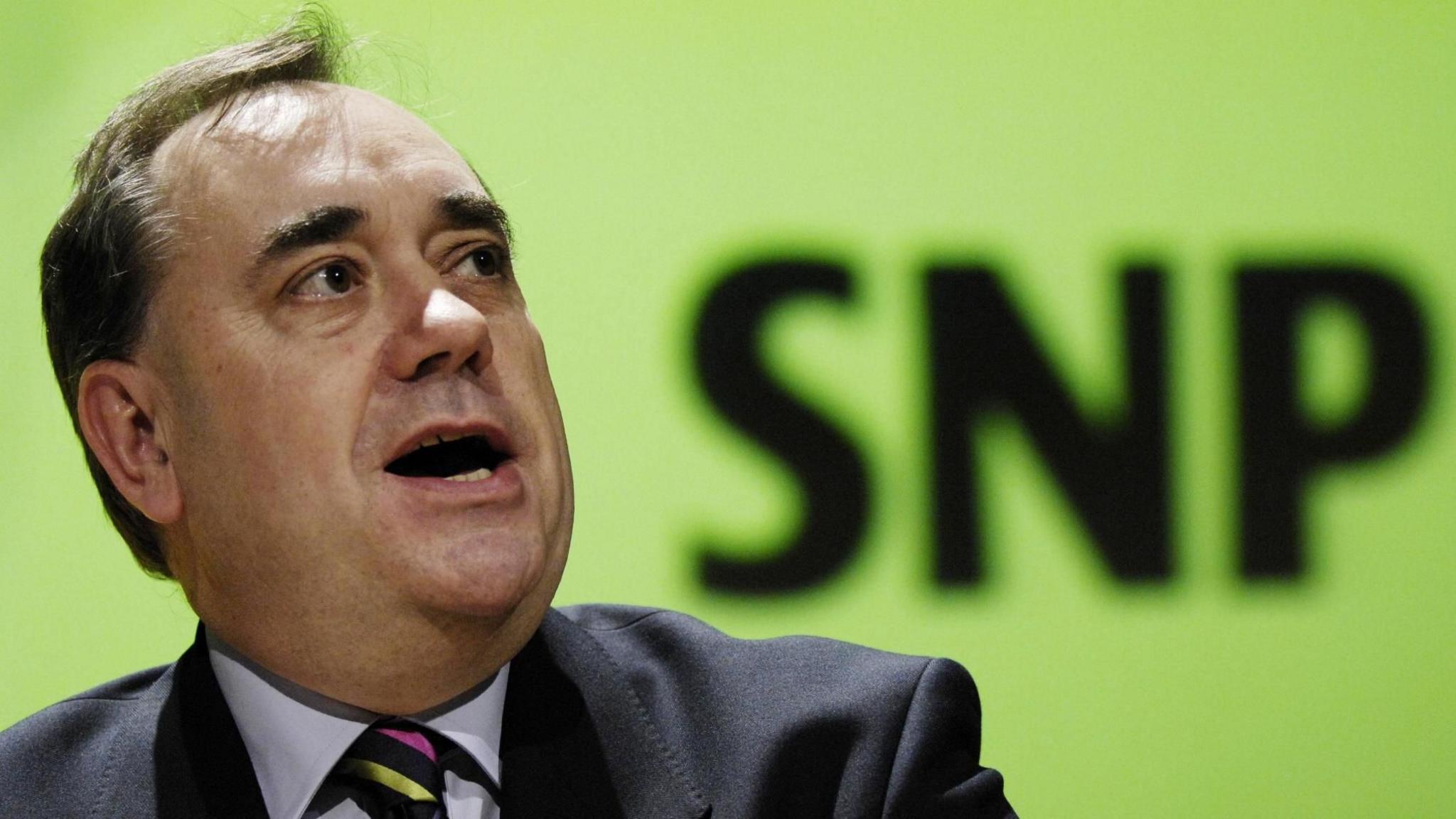 Alex Salmond speaking in 2007 in front of an SNP logo