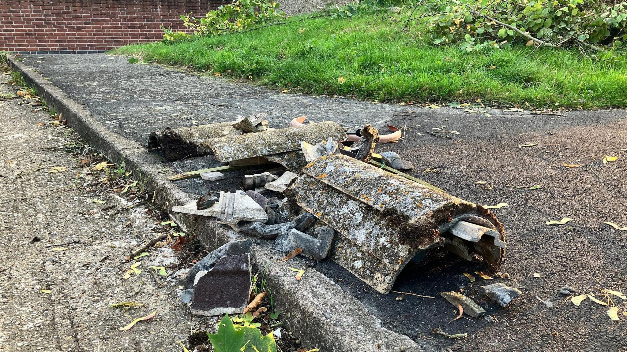 Some roof tiles can be seen on the pavement