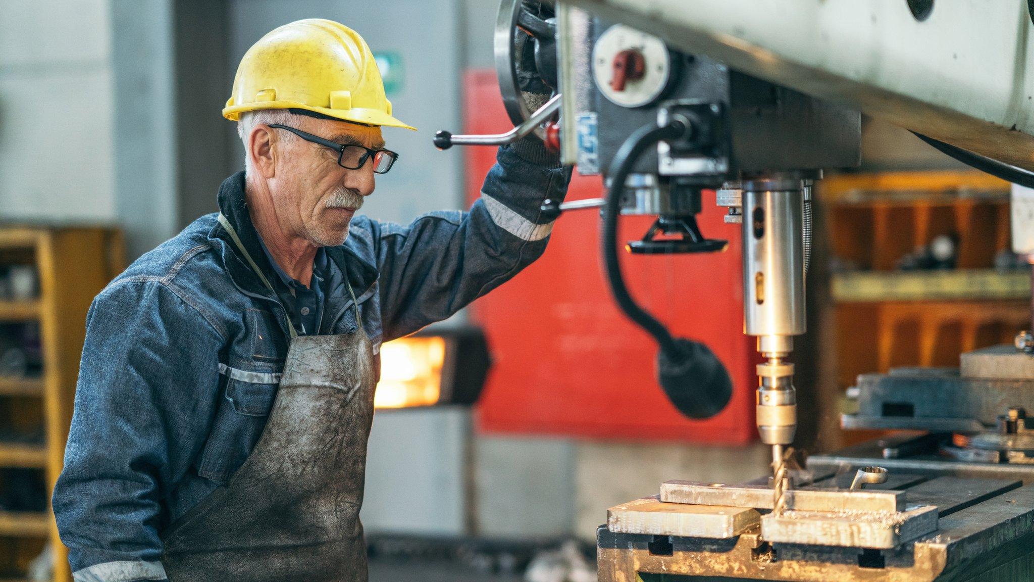 Older man working on a drill bit.