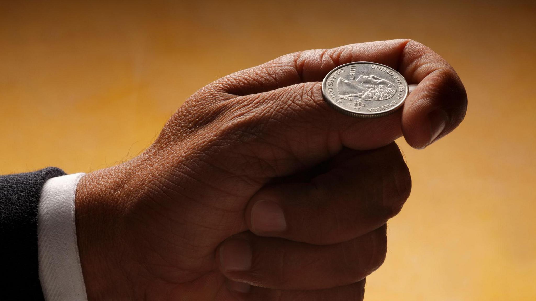 Man gets ready to flip a silver coin