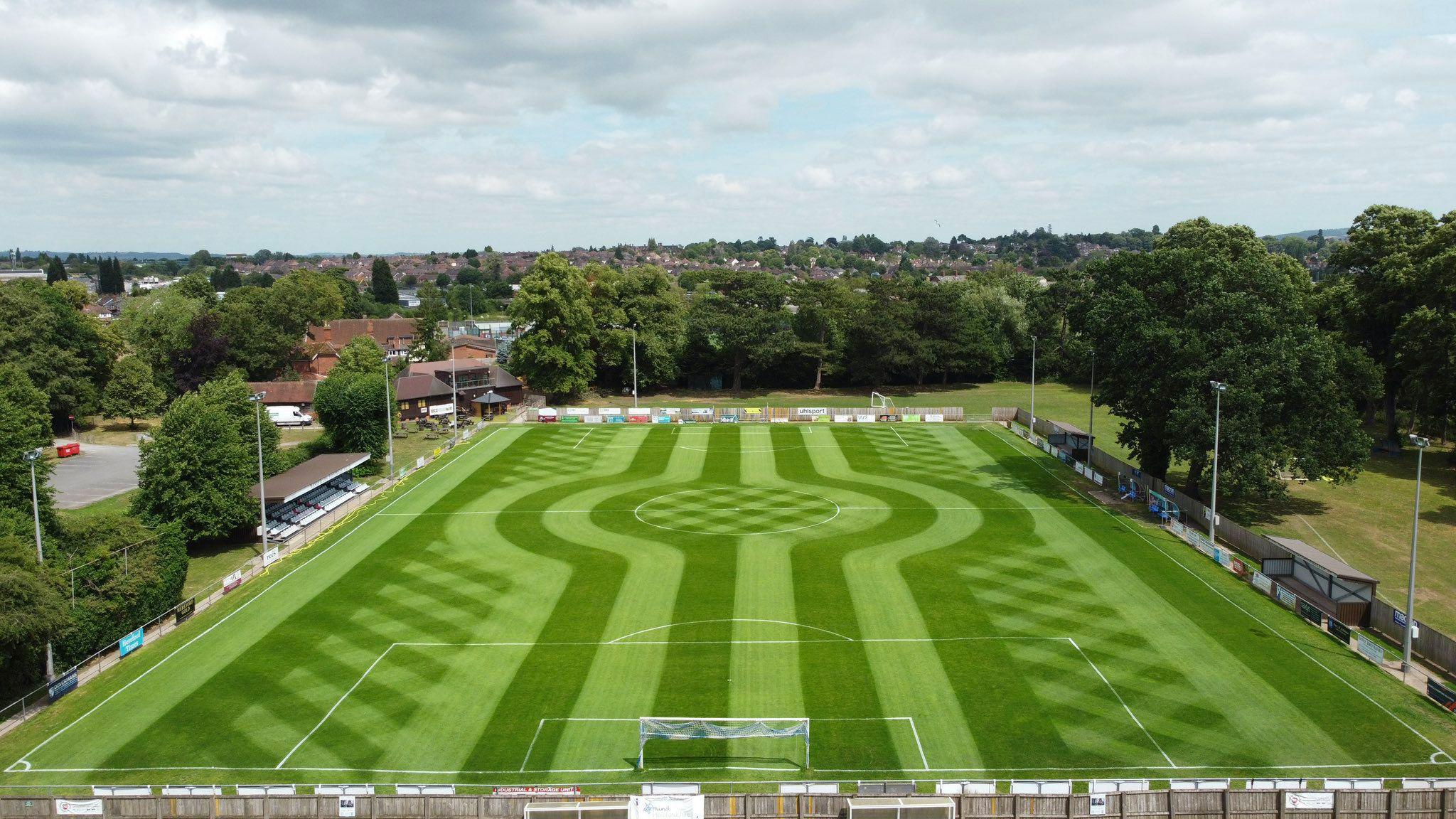 A football pitch with mowing designs including straight lines, curves and diagonal stripes