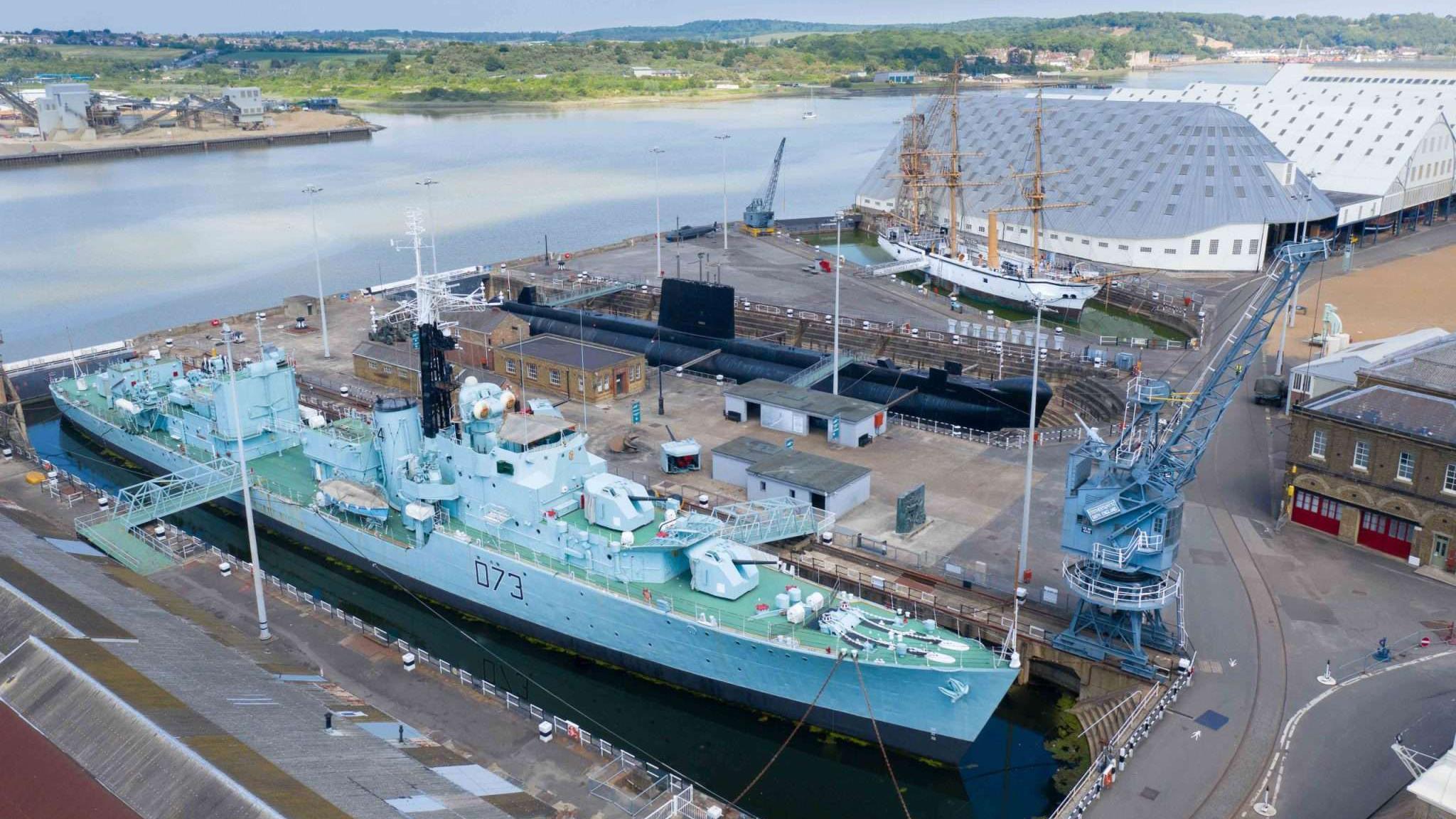 Aerial shot of historic ships and submarine in dry docks at Historic Dockyard Chatham with River Medway in background
