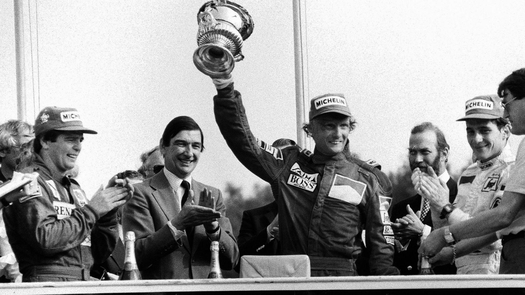 Niki Lauda celebrates winning the 1984 British Grand Prix as Derek Warwick and Ayrton Senna look on