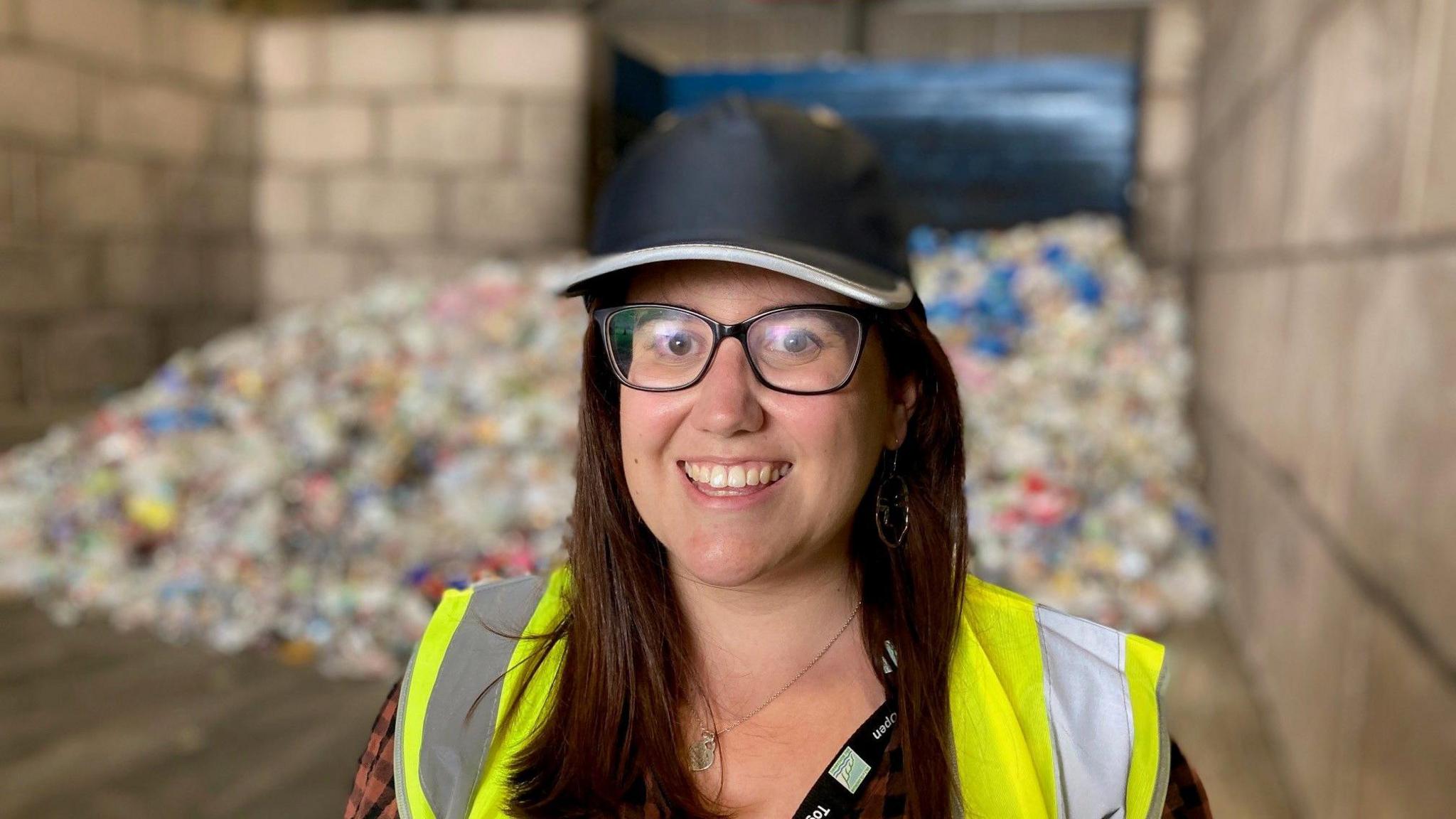 Hollie Smith o Gyngor Bro Morgannwg yn sefyll mewn canolfan ailgylchu