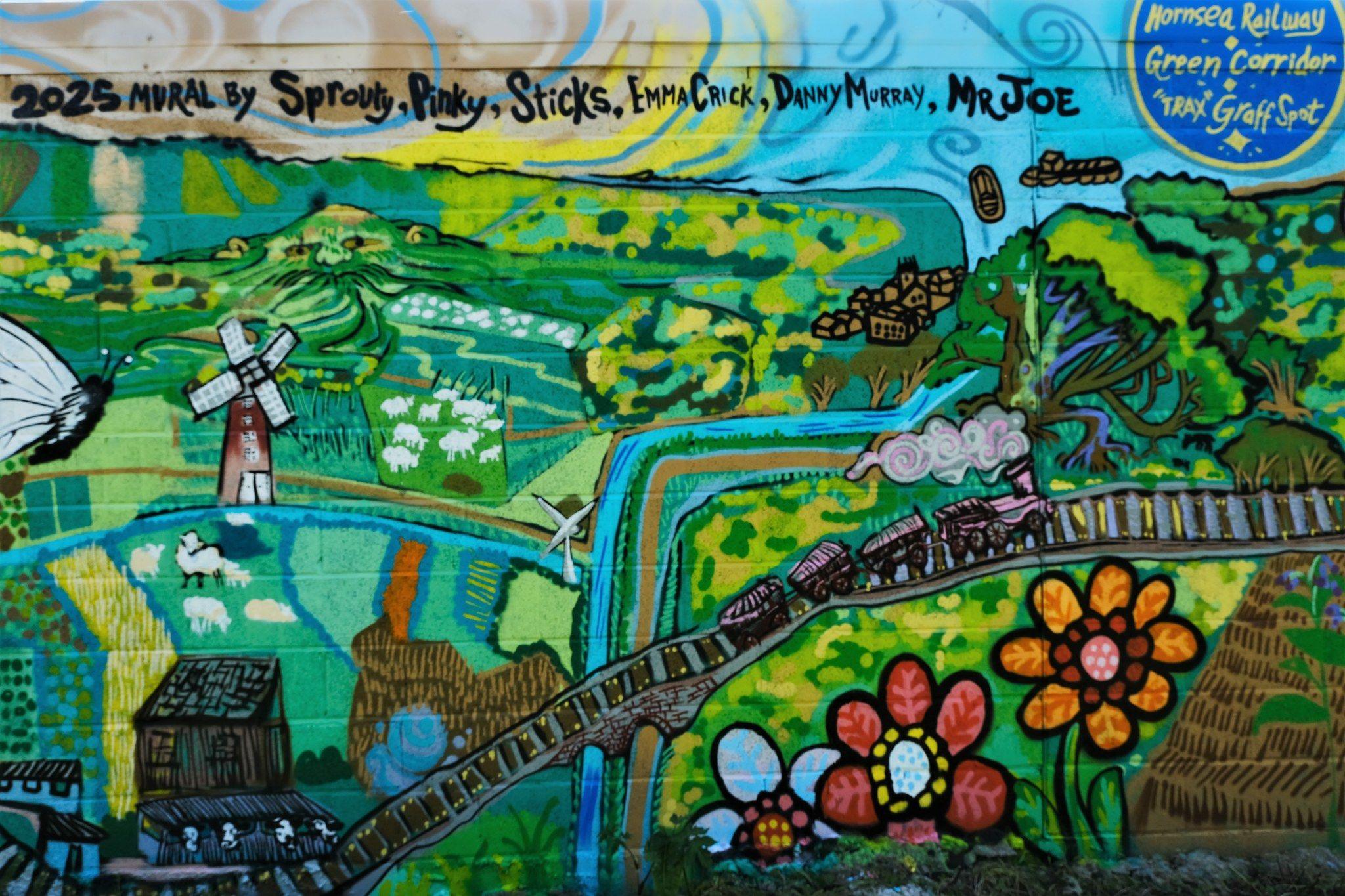 A painted mural depicting the East Yorkshire landscape with fields and streams. A railway line runs through the centre of the image with a steam train running along it.