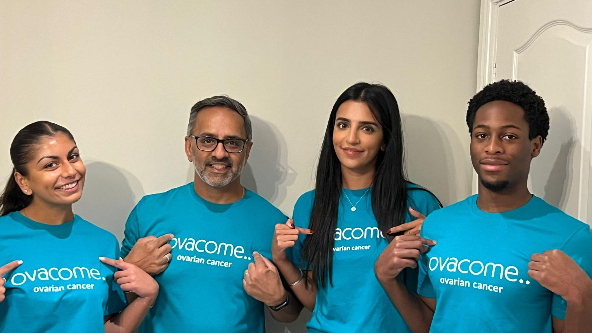 Two men and two women - each wearing a blue t-shirt with the Ovacome logo