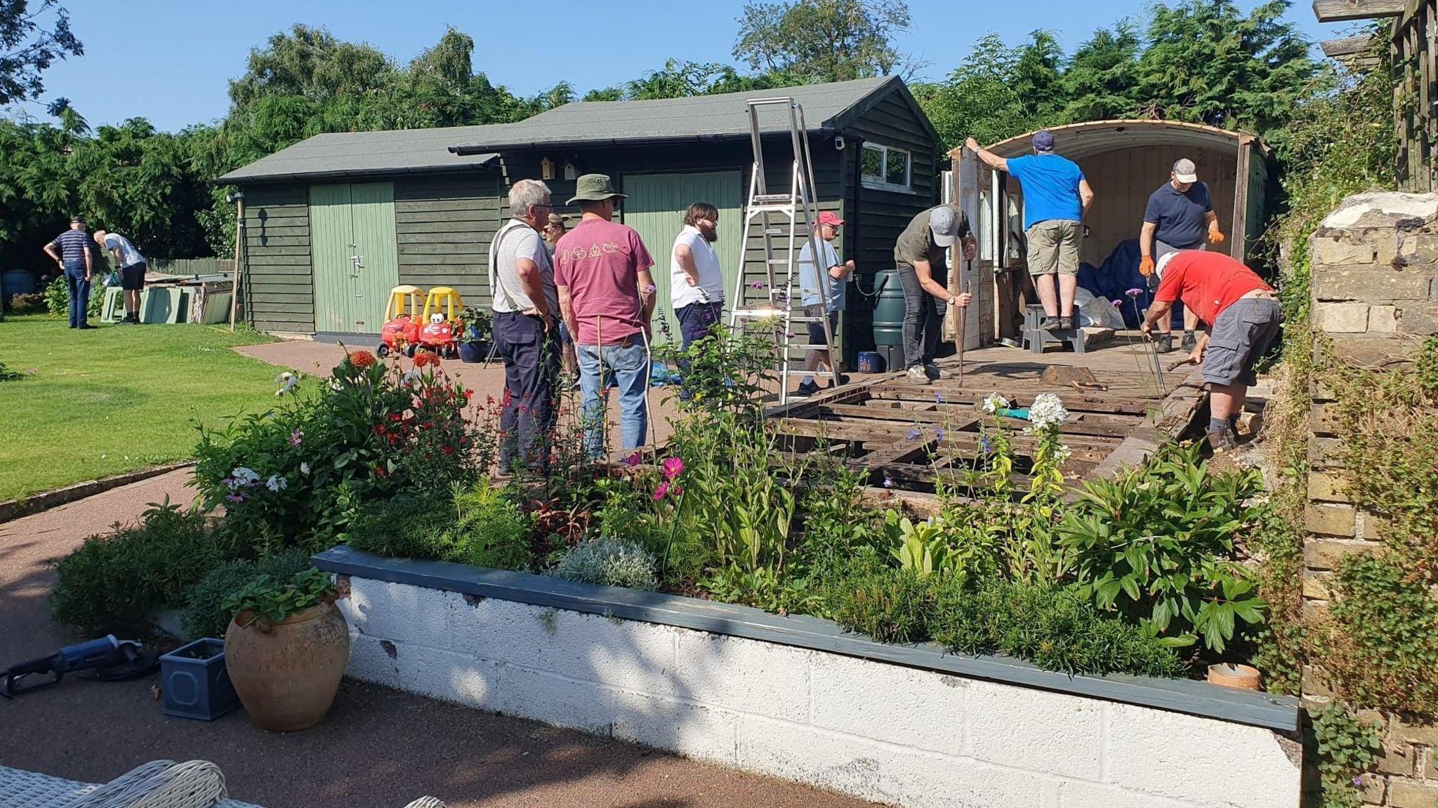 A group of people dismantling the railway carriage