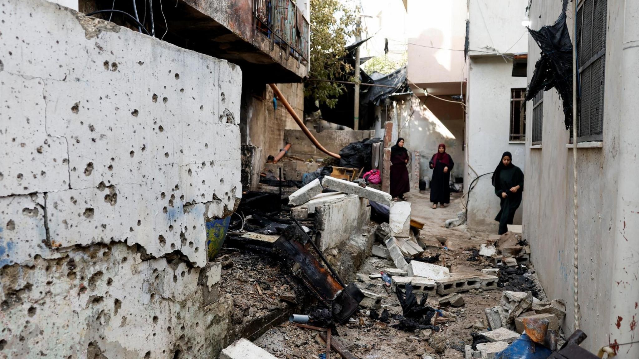 Palestinian women stand near a house damaged by an Israeli drone strike in Nur Shams refugee camp, near Tulkarm, in the occupied West Bank (27 August 2024)