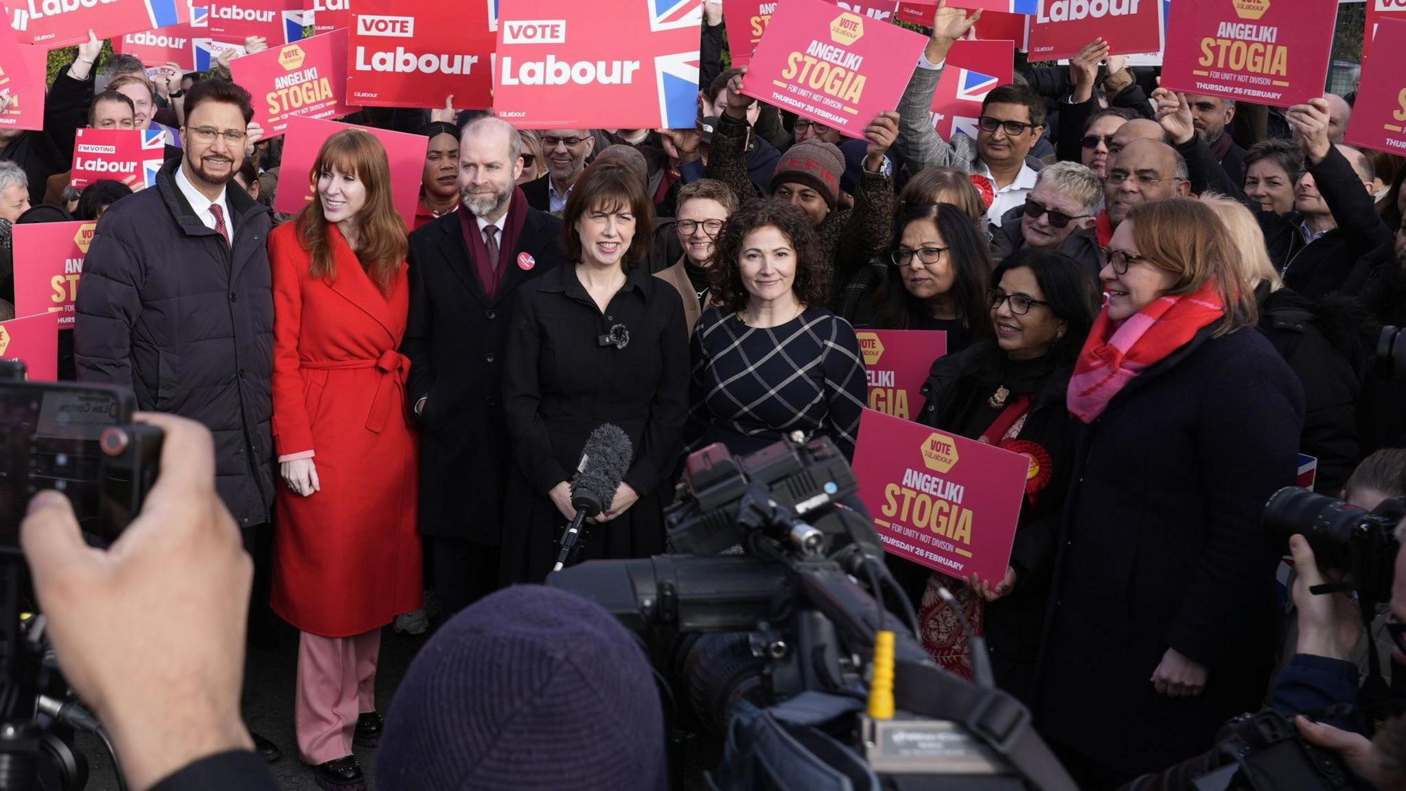 Labour MPs Afzal Khan, Angela Rayner, Jonathan Reynolds and Lucy Powell on the left with other activists around her as they pose for photographers and camera crews.