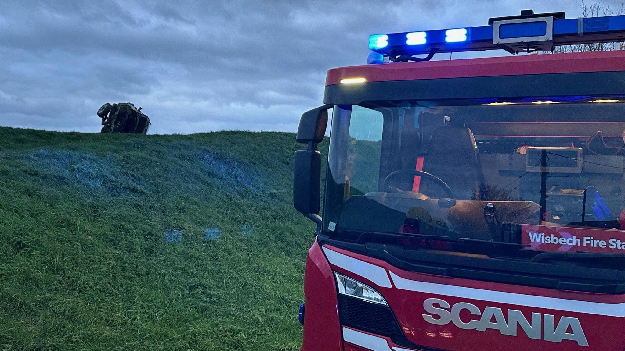 A care and a fire engine by a river bank