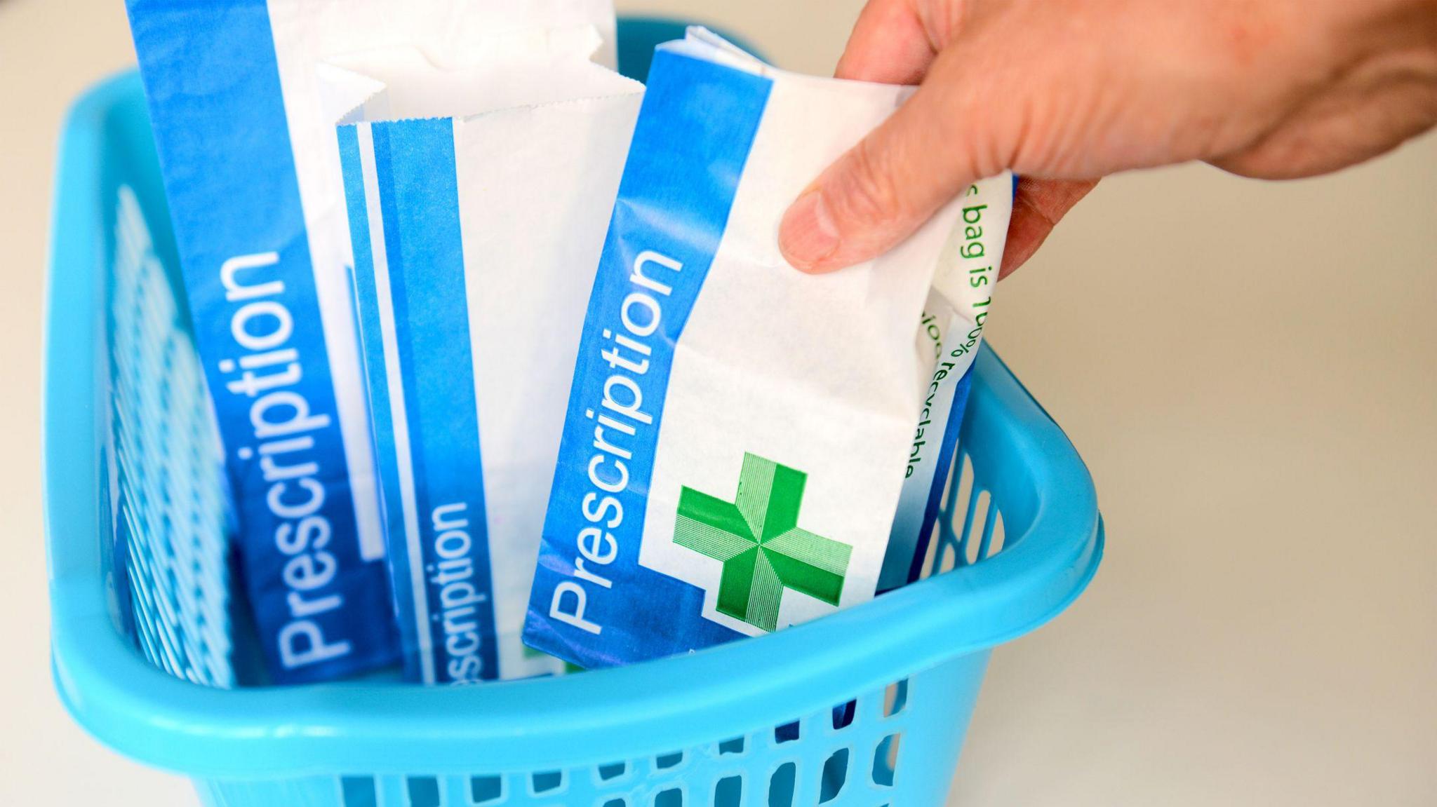 A basket with three paper bags with a medical symbol on and the word 'Prescription'.