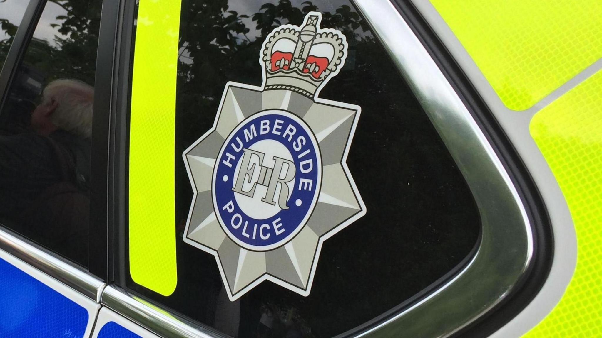 A Humberside police logo on the window of a police car.
