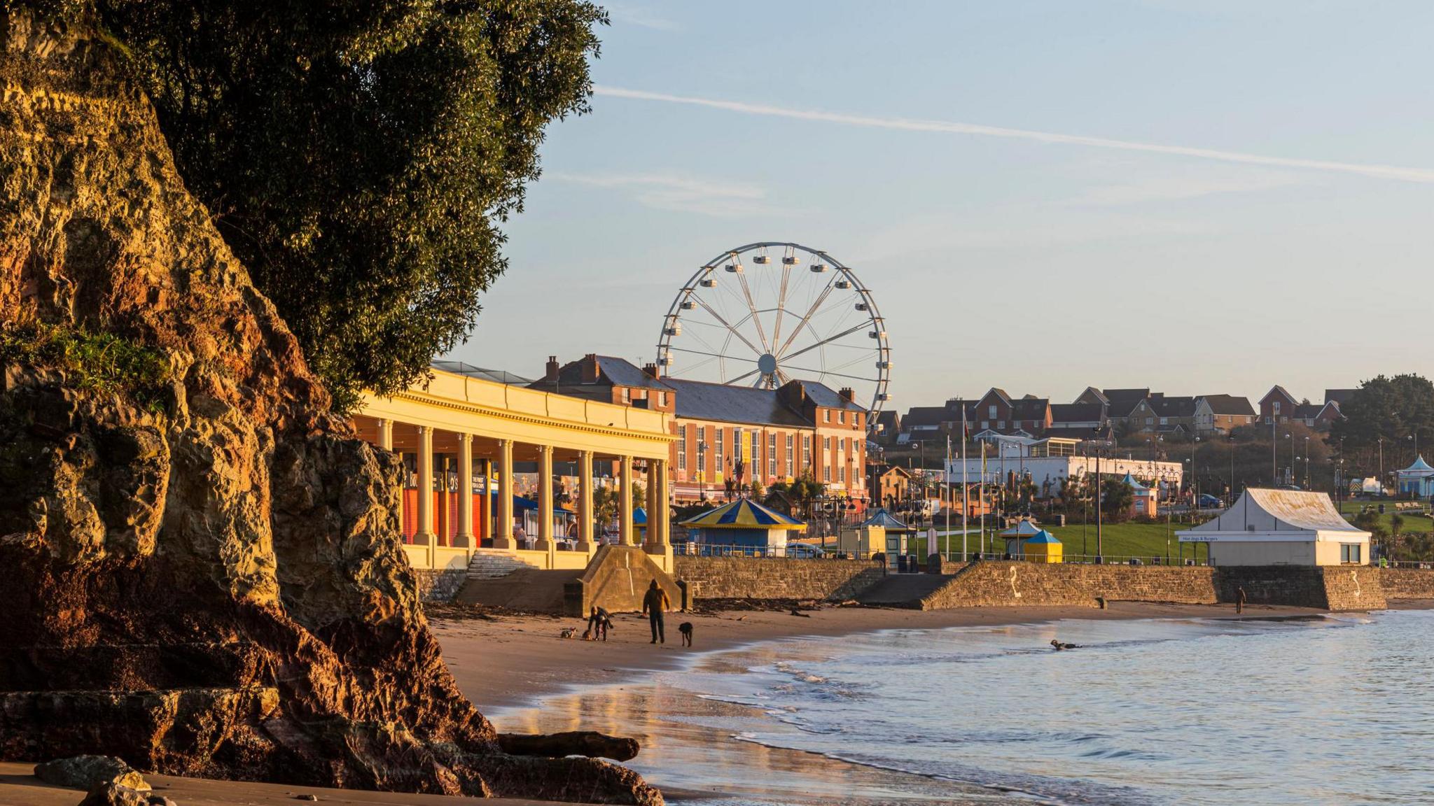 Barry Island beach and promenade seen from the beach. The town is visible in the background with a ferris wheel