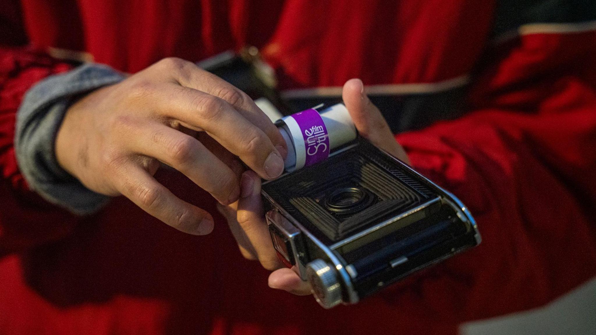 Fabriccio Díaz is loading film into a camera that was made in the 1930s, which he was allowed to borrow from a camera store and try out. 