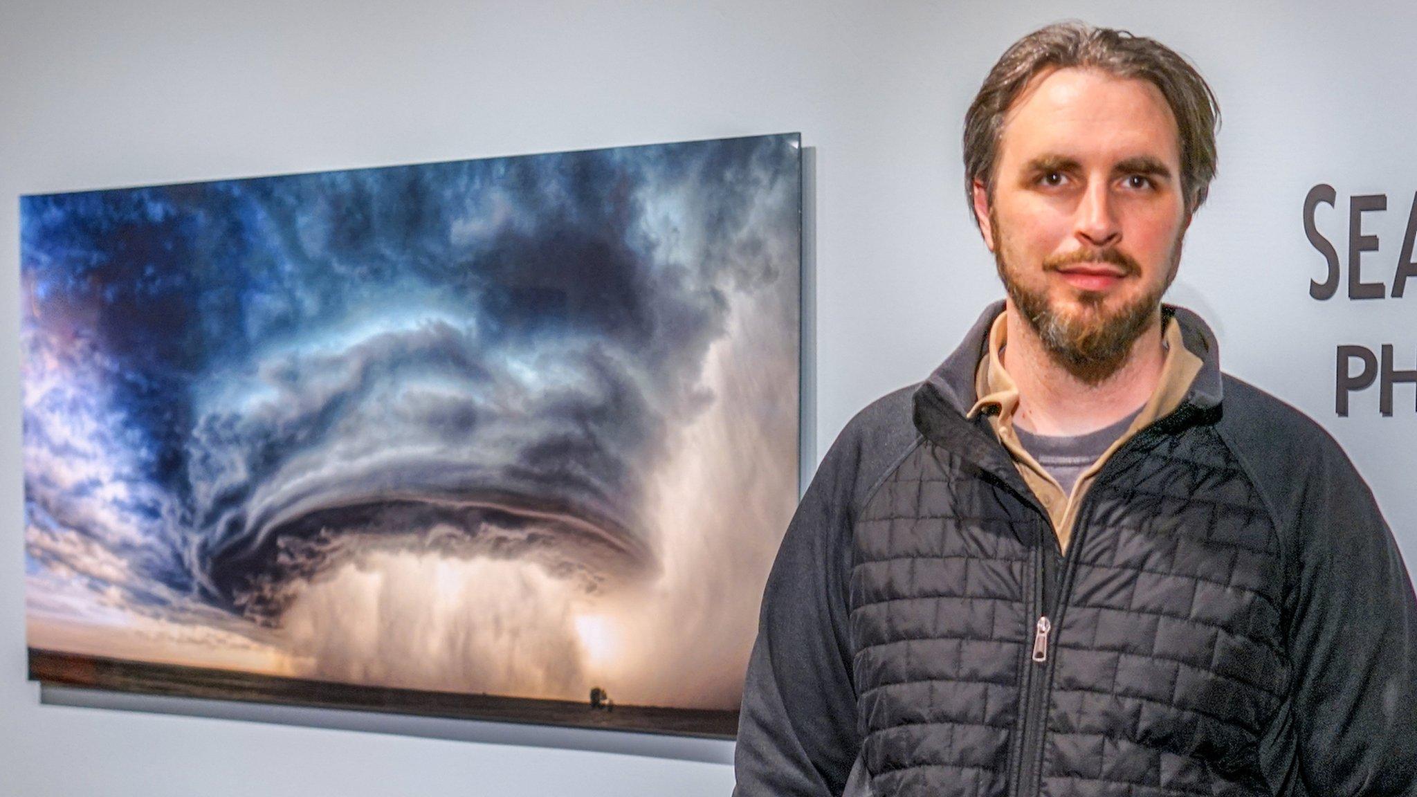 Sean Heavey stands in front of his picture, "The Mothership"