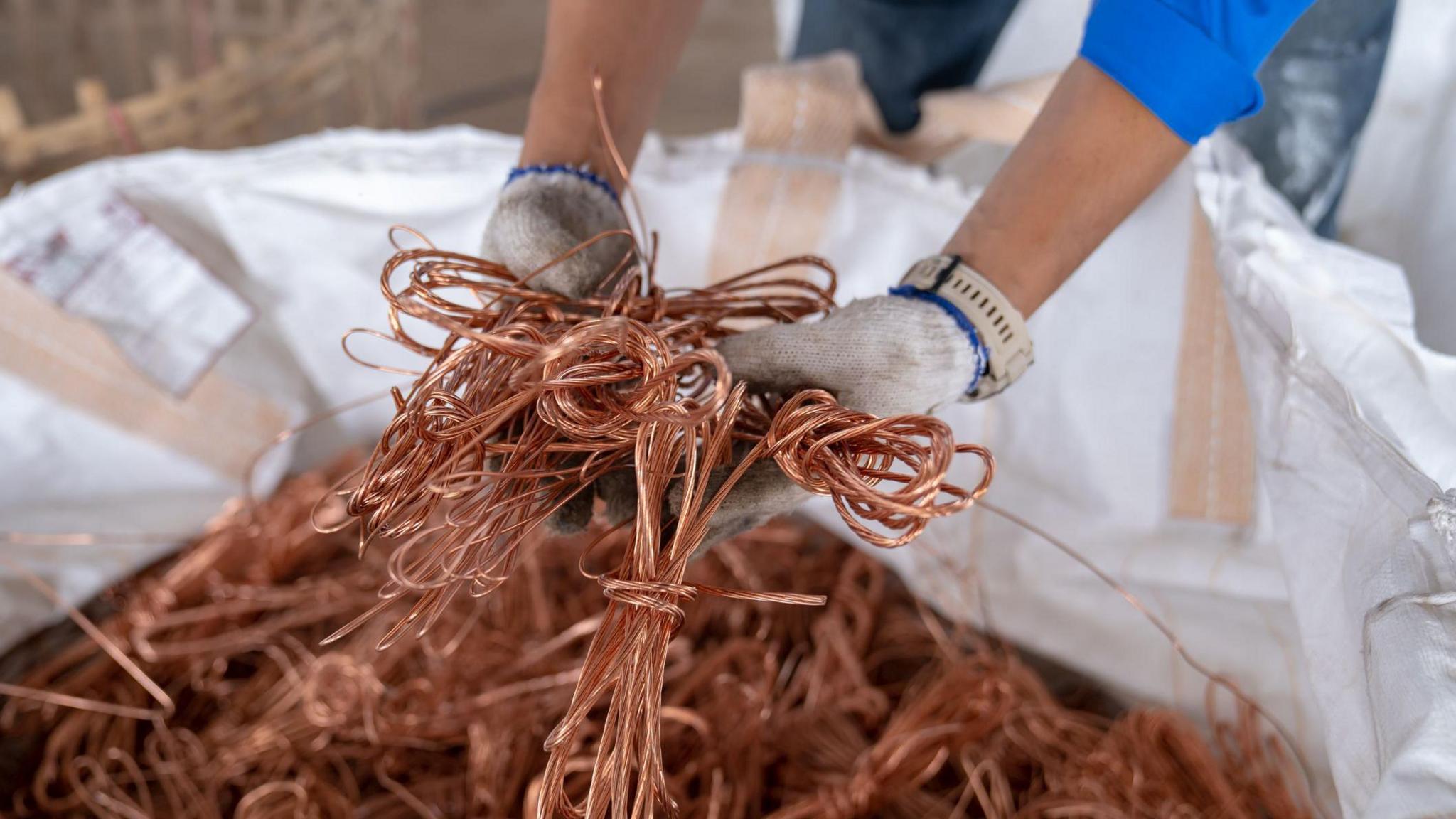 hands holding copper wires