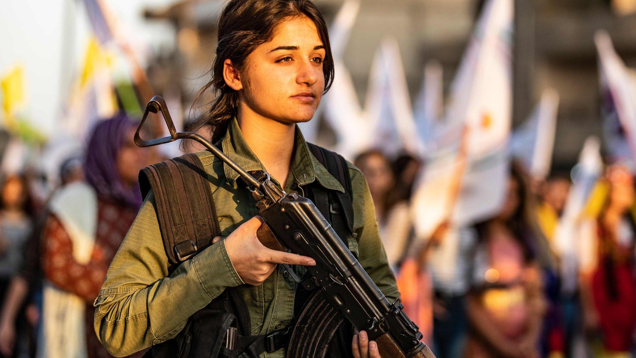 A member of the Syrian Kurdish internal security forces stands guard as Kurds protest in Qasmishli against Turkish threats to launch an offensive on northern Syria (27 August 2019)