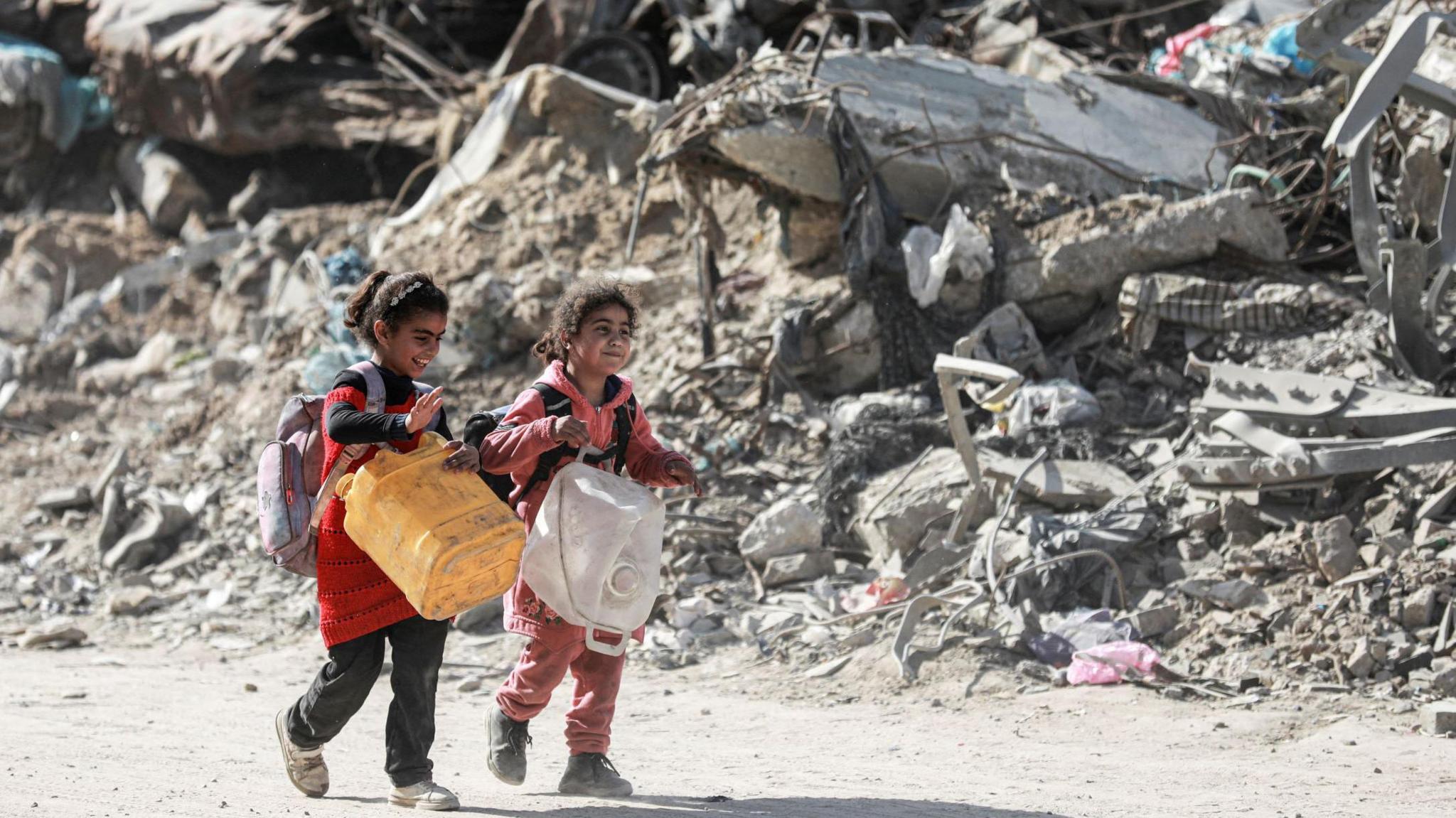 Two children walking past rubble after an air strike in Gaza 