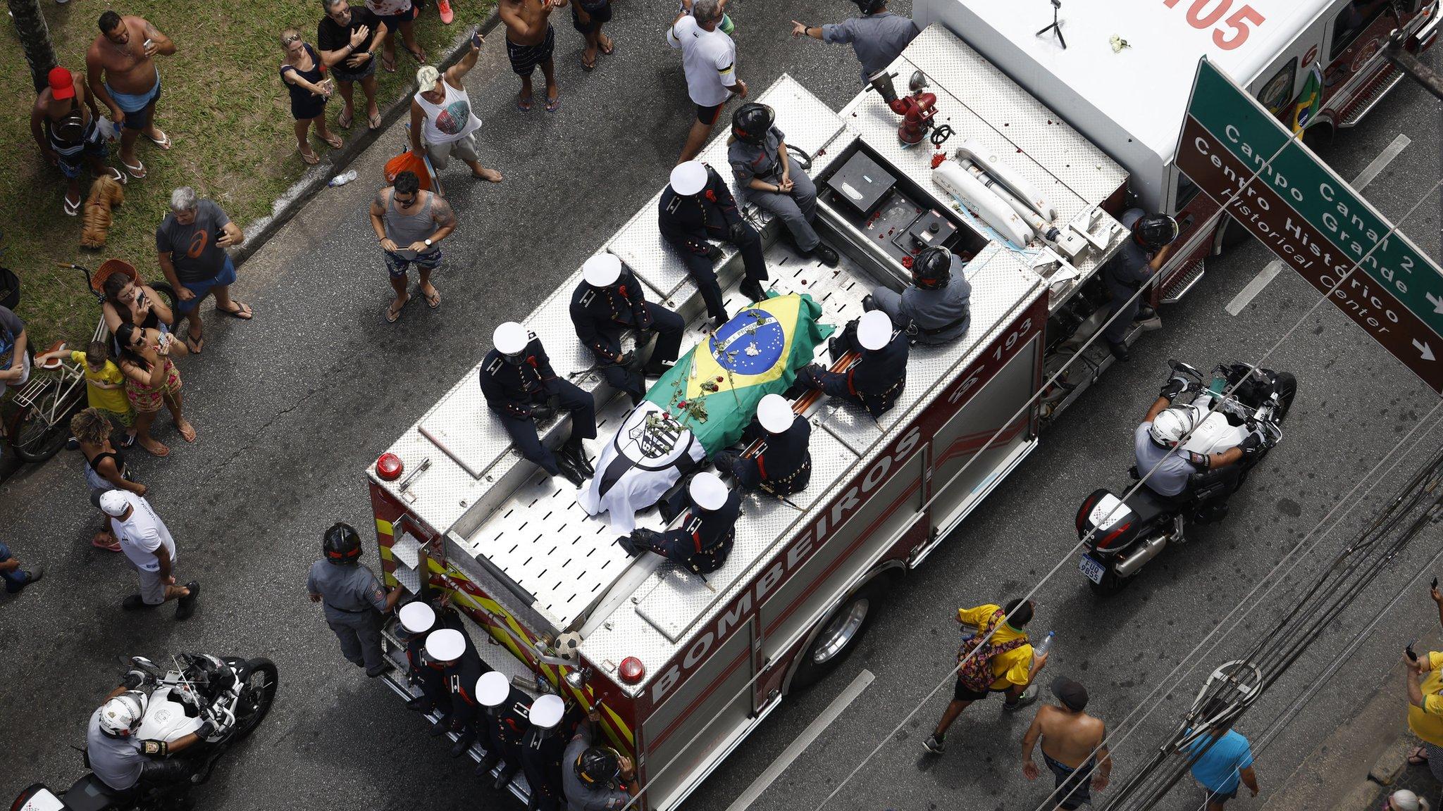 Fire truck carrying Pele's coffin which is draped in a Brazil flag