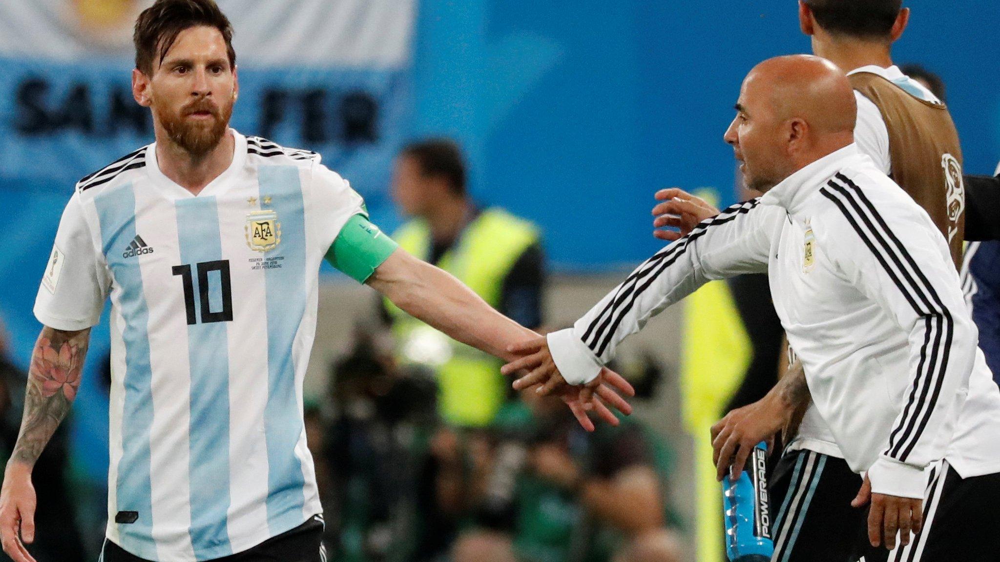 Lionel Messi and Jorge Sampaoli touch hands during their game against Nigeria